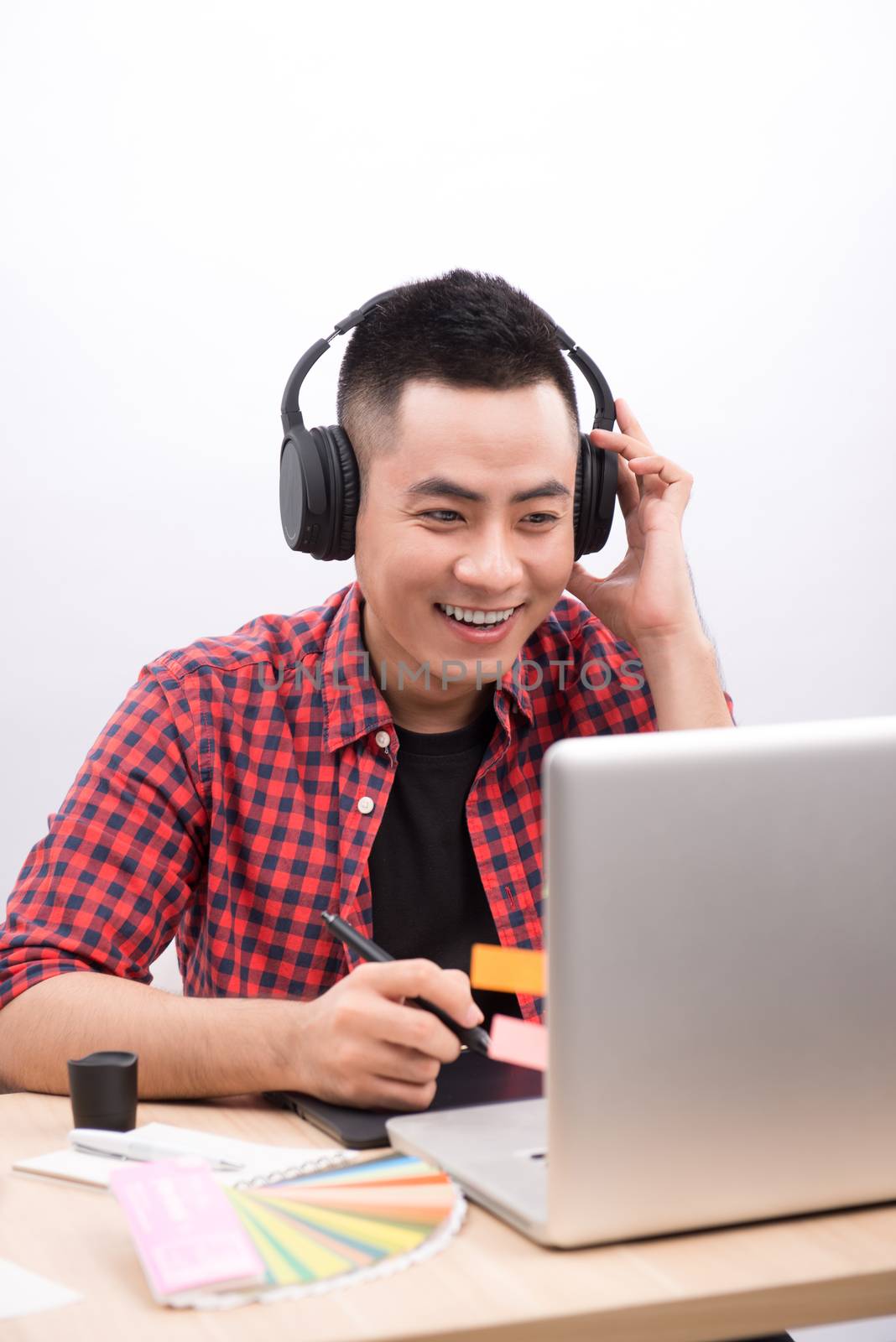 Happy designer working on his laptop in creative office by makidotvn