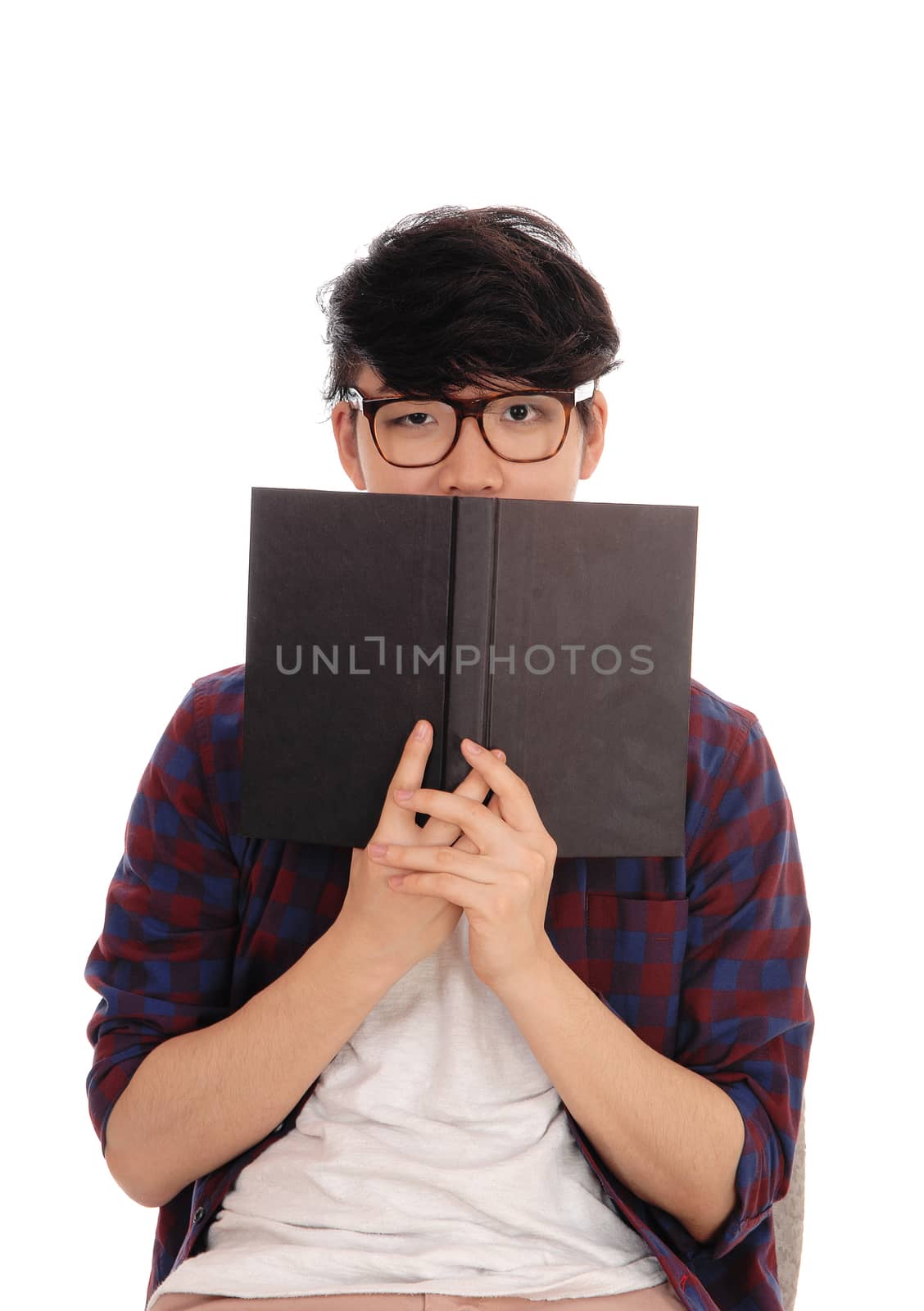 Asian man holding book for face. by feierabend