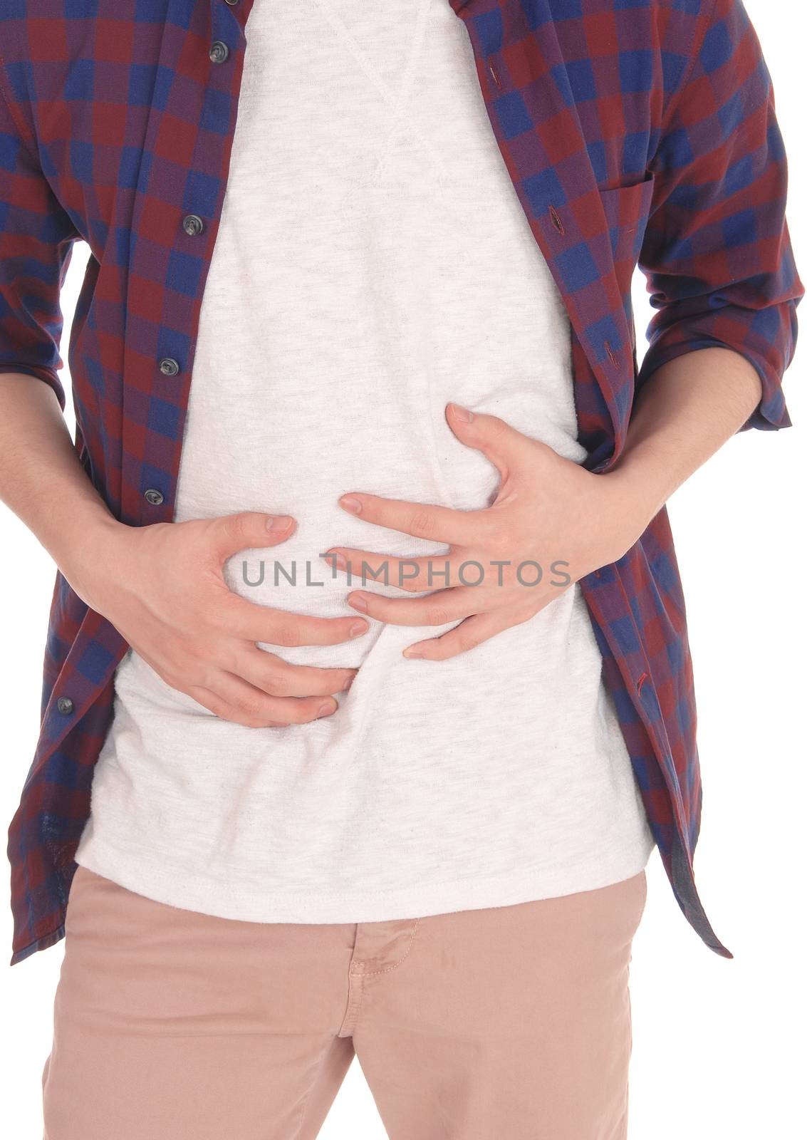 The middle section of a young man standing in a checkered shirt
and holding his hands on his stomach for pain, isolated over white.
