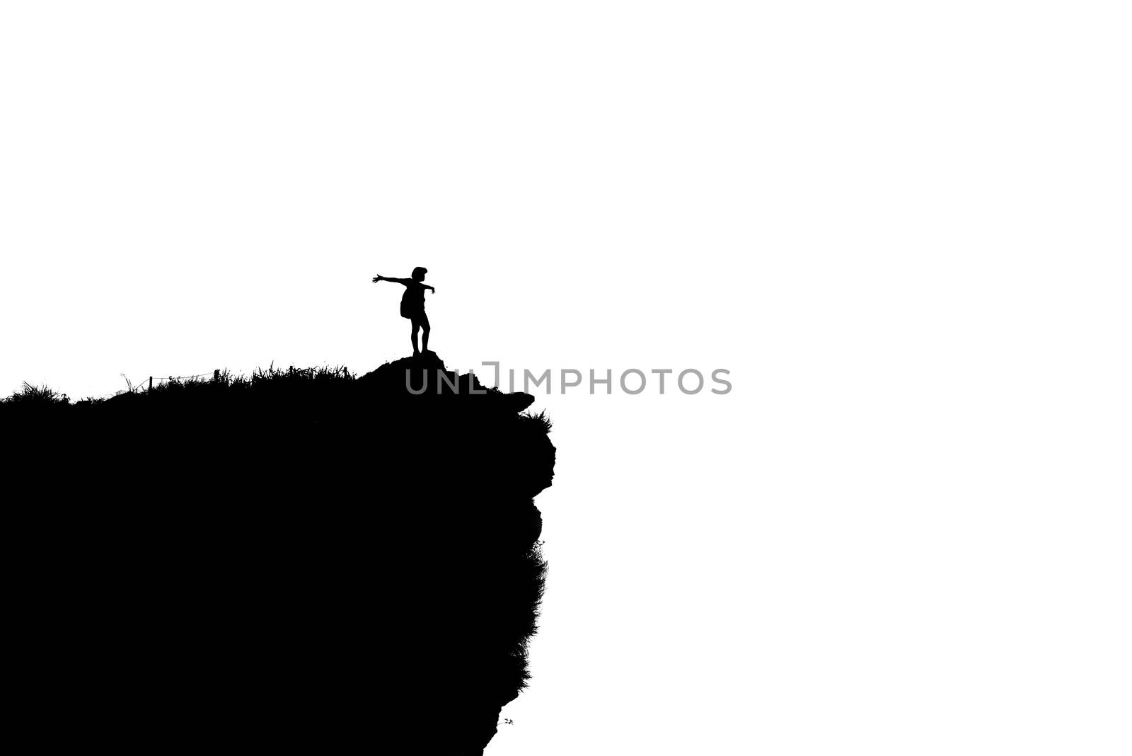 Black and white silhouette background of woman tourist standing arms outstretched happy with success on peak mountain near the cliff at Phu Chi Fa Viewpoint in Chiang Rai Province, Thailand