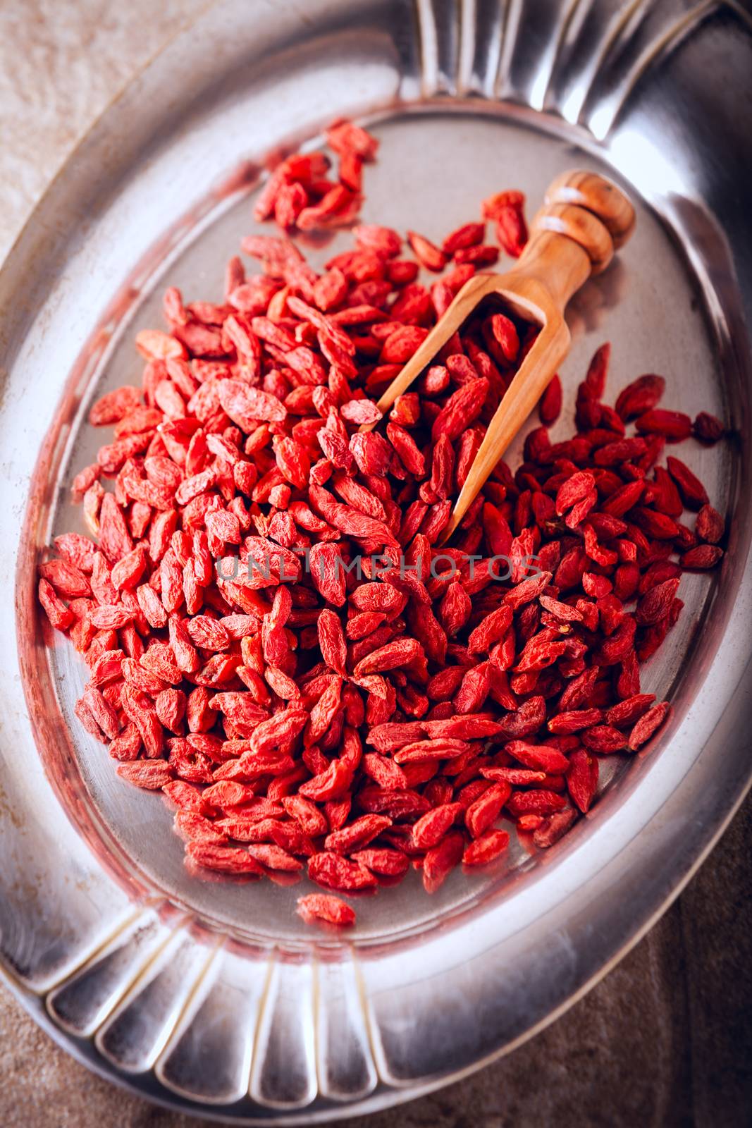 Dried goji berries with wooden spoon on a tray