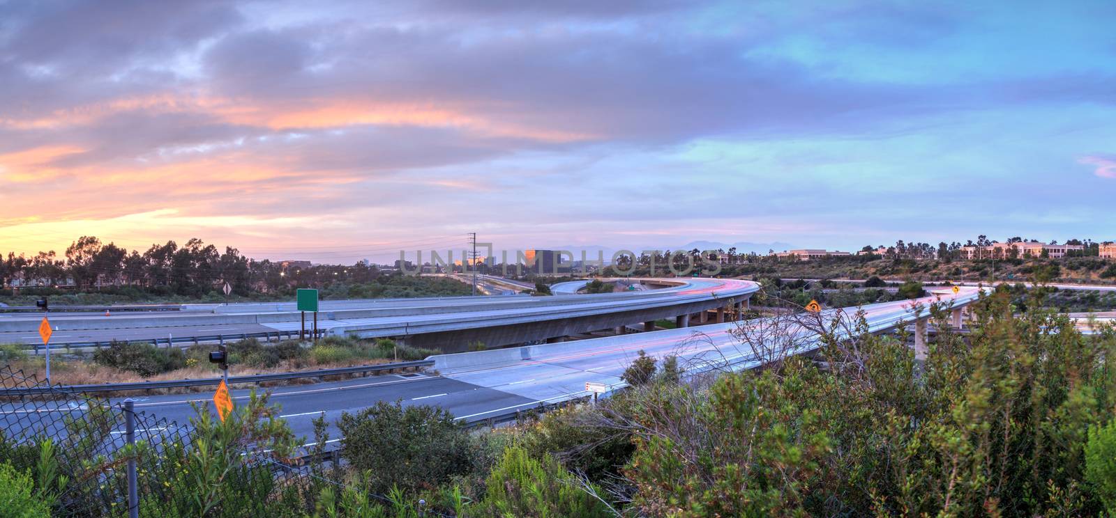 Car headlight trails at sunset traveling across a highway in Newport Beach, California