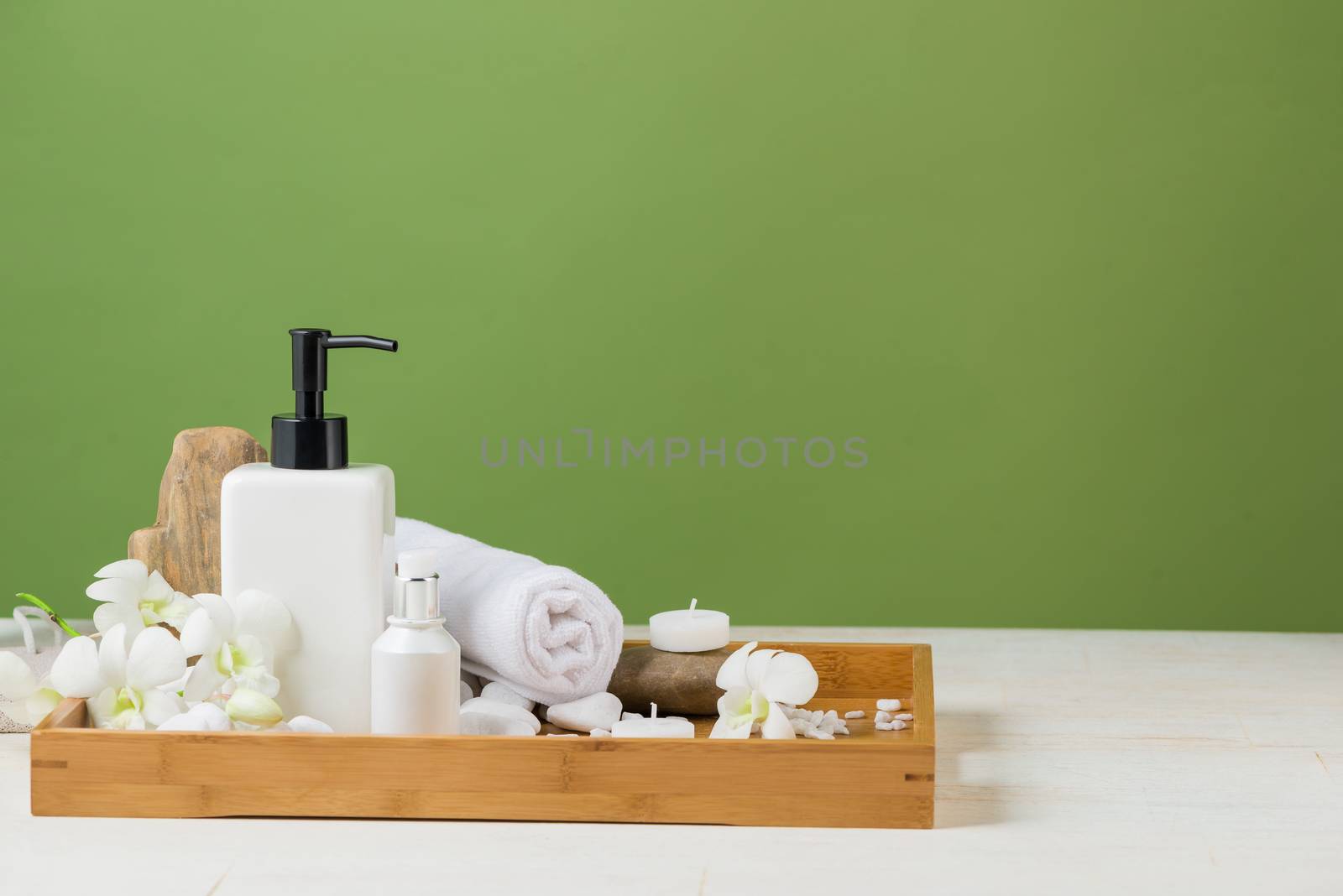 SPA Decoration. Spa composition with cosmetic bottle over green.
