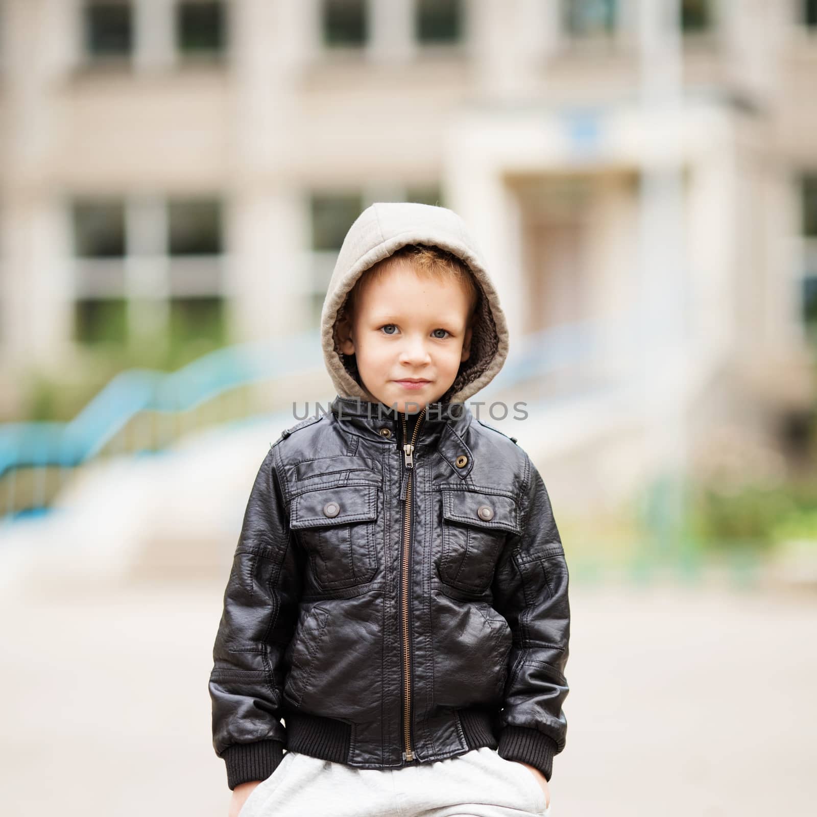 portrait of adorable little urban boy wearing black leather jacket. City style. Urban kids.