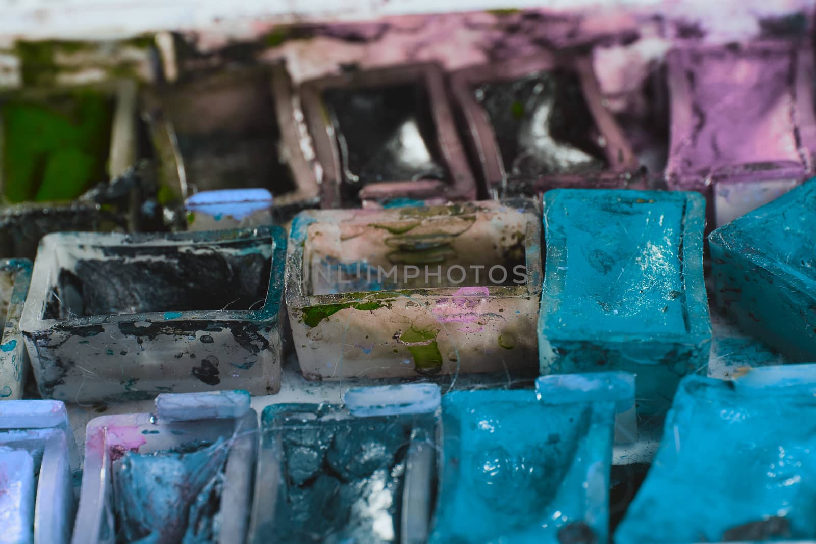 artists brushes and watercolour paints on palette. Vintage stylized photo of paintbrushes closeup and artist palette. Used palette with paintbrush