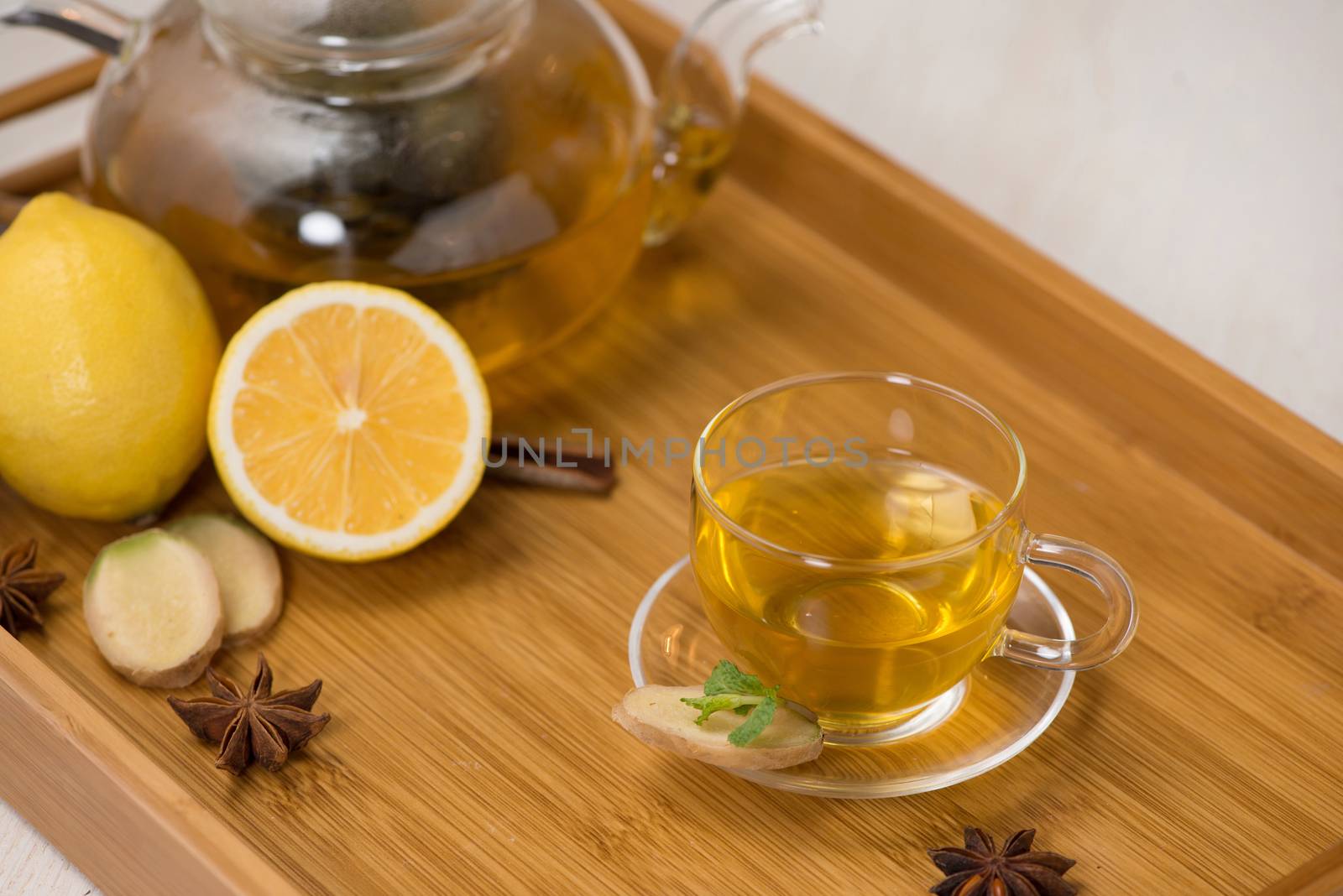 Cup of ginger tea with lemon and honey on white wooden background.