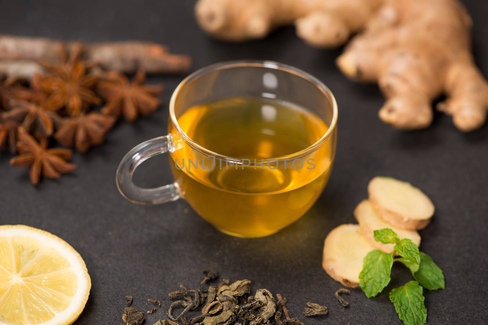 Cup of ginger tea with lemon and honey on dark stone background by makidotvn