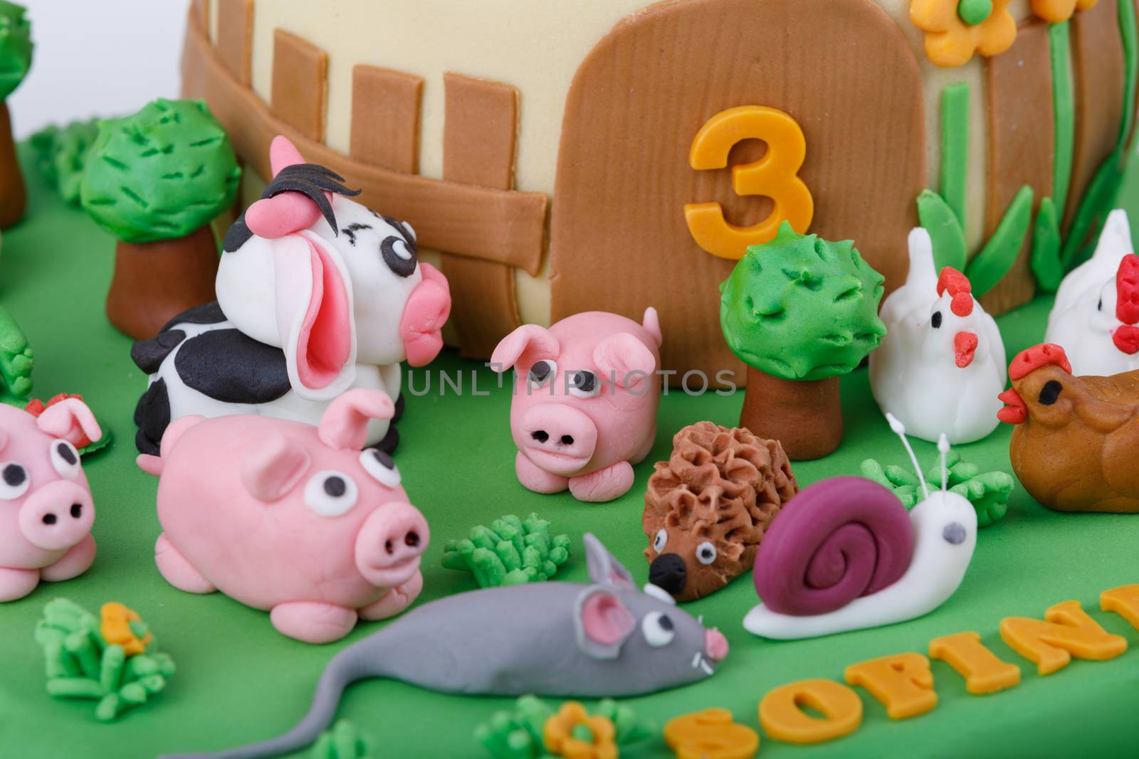 detail of birthday cake with farm marzipan animals and number 3