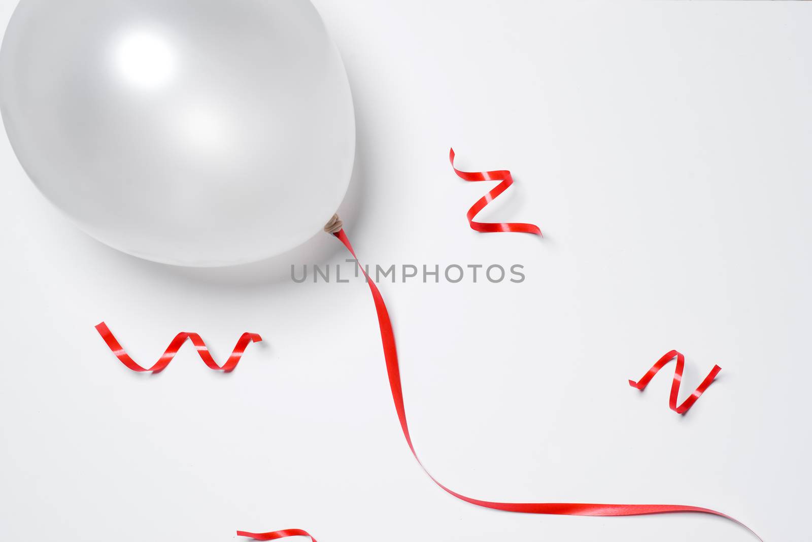 Festive red ribbon and white balloon isolated on white background