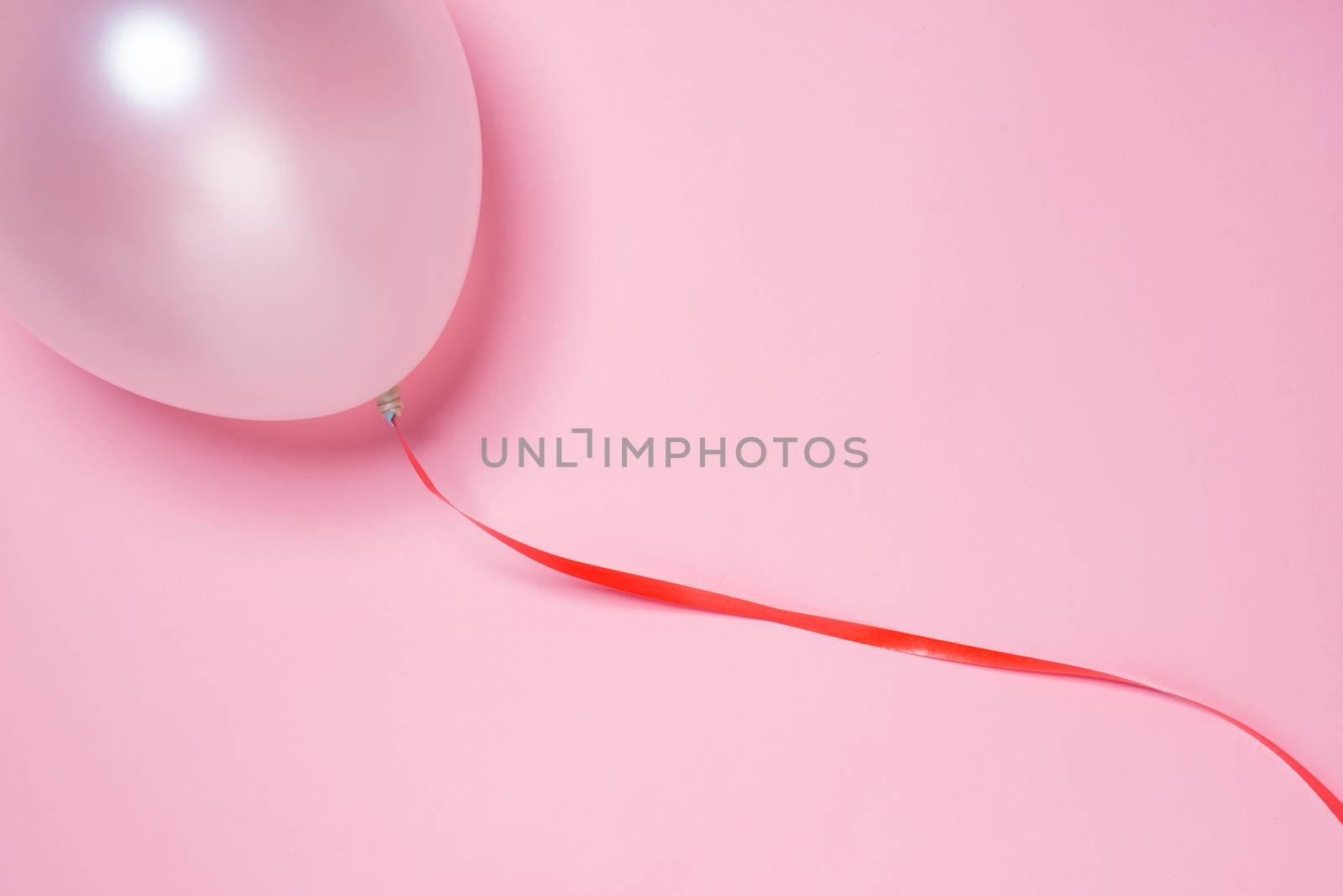 Festive ribbon and white balloon isolated on pink background by makidotvn