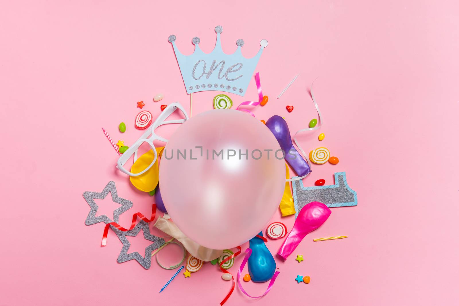 Celebration Flat lay. Candy with colorful party items on pink background.