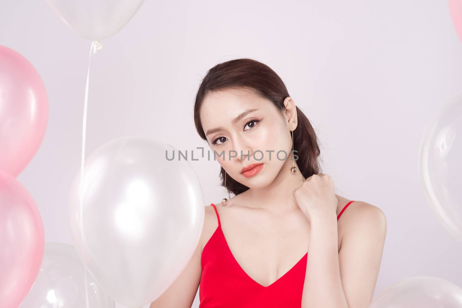 Asian beautiful woman in red dress with pastel balloons