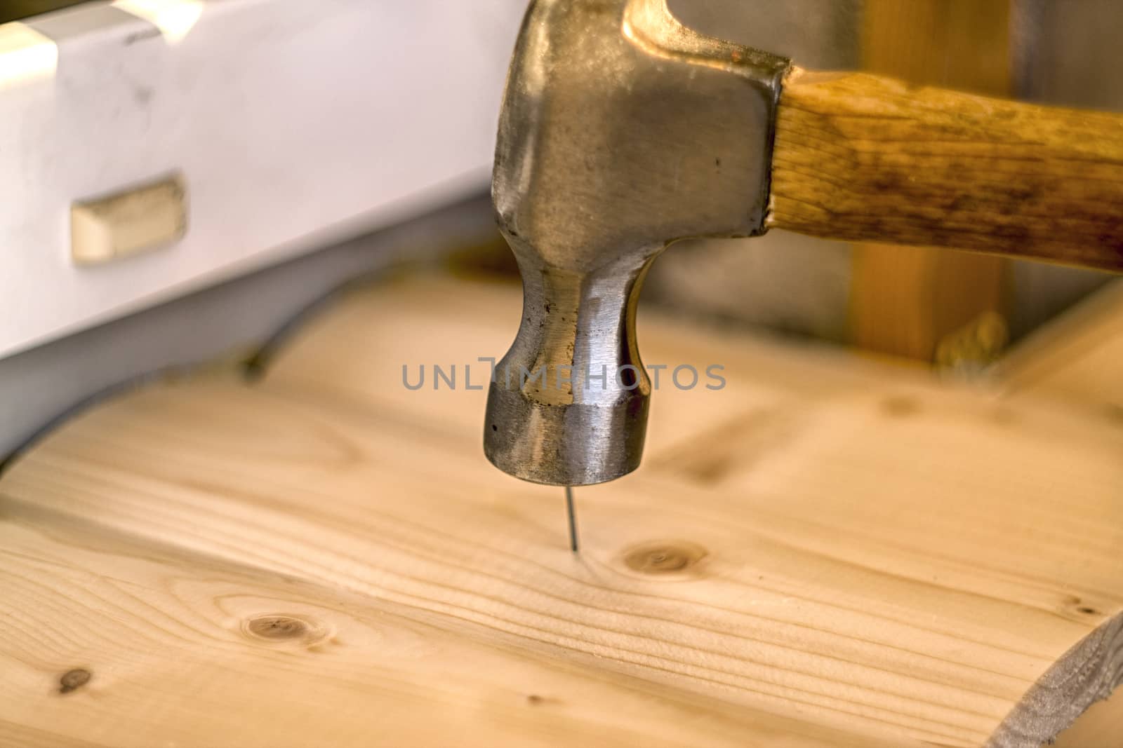 Hammer clogs a nail into a wooden board by nolimit046