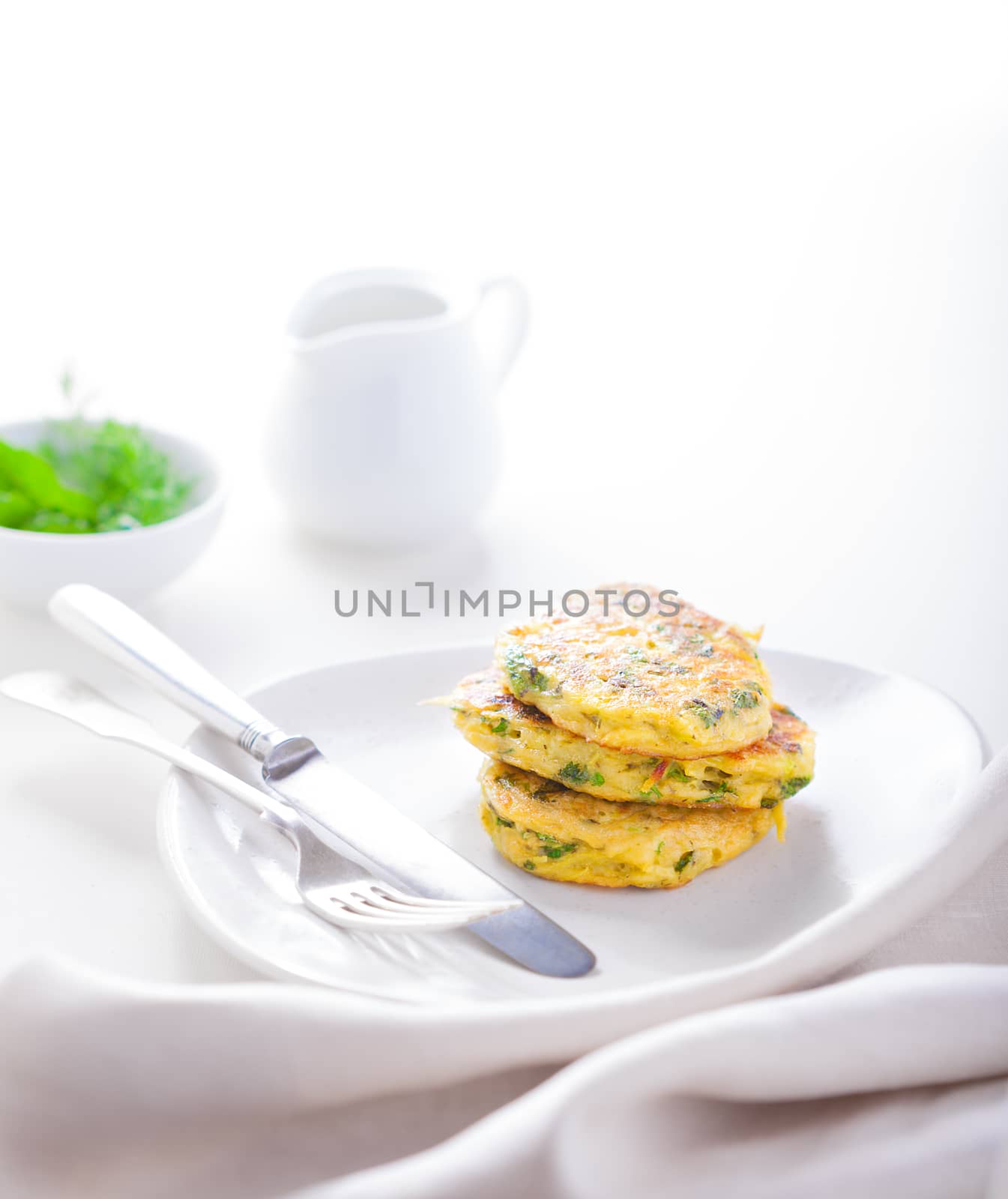 Healthy vegetarian zucchini fritters on a white plate