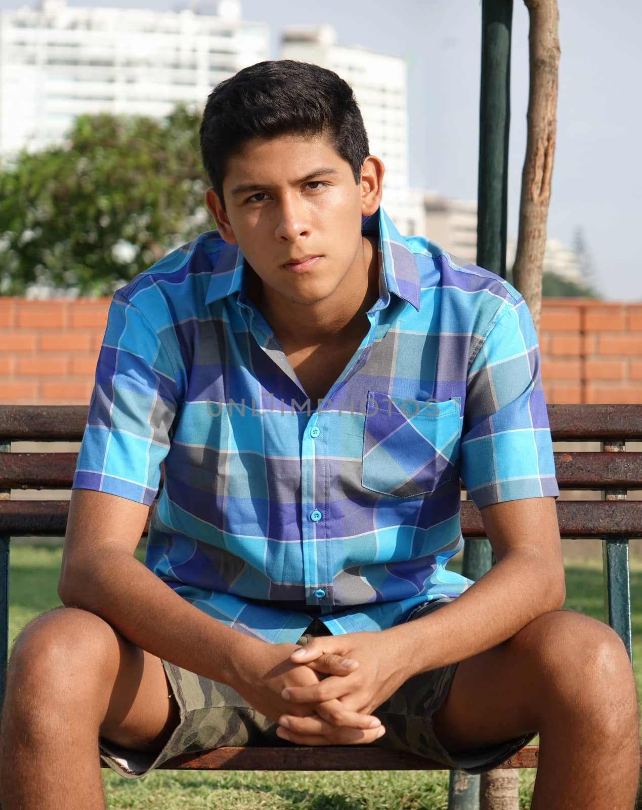 Teen Boy Sitting In Park by dtiberio