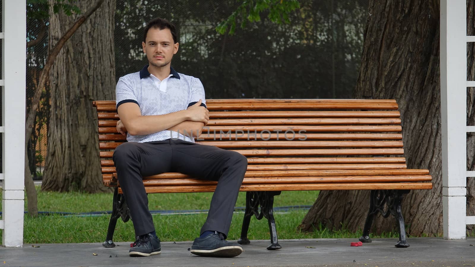 Man Sitting Alone On Park Bench by dtiberio