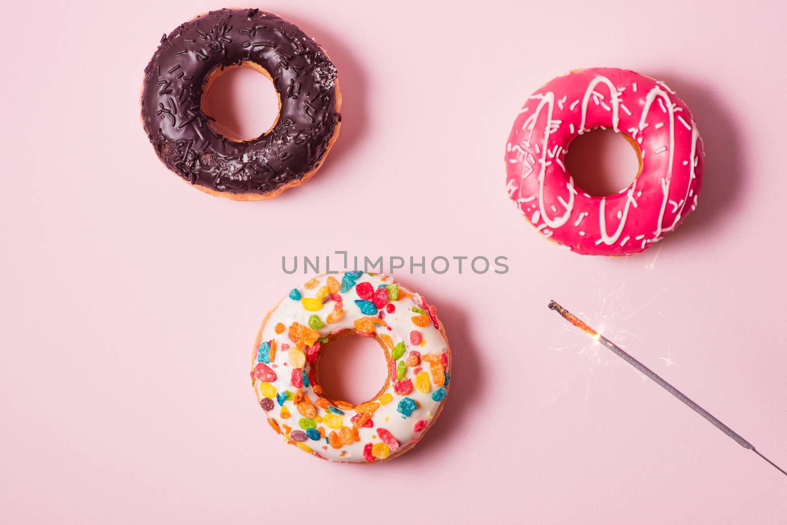 Delicious donuts for birthday on pastel pink background.