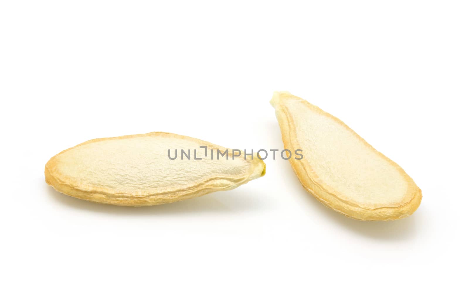 Closeup of dried pumpkin seeds on a white background