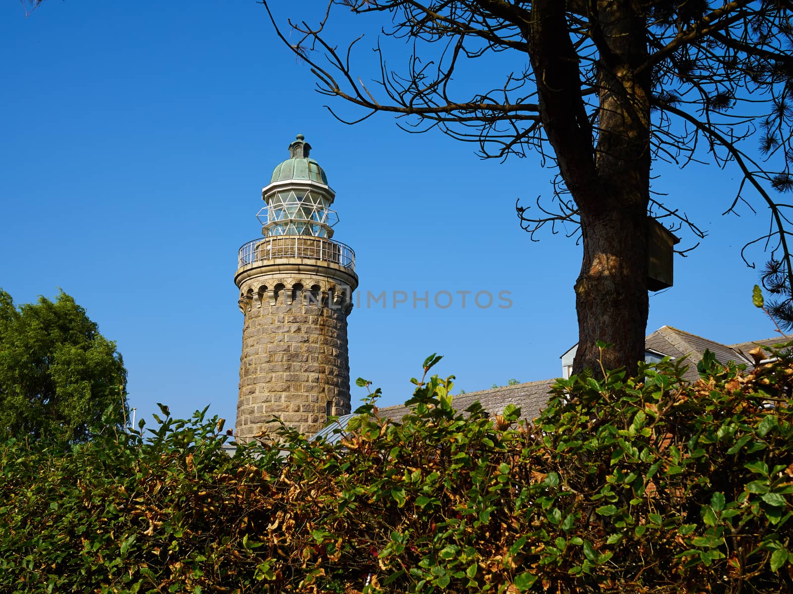 Old stone lighthouse on the beach by Ronyzmbow