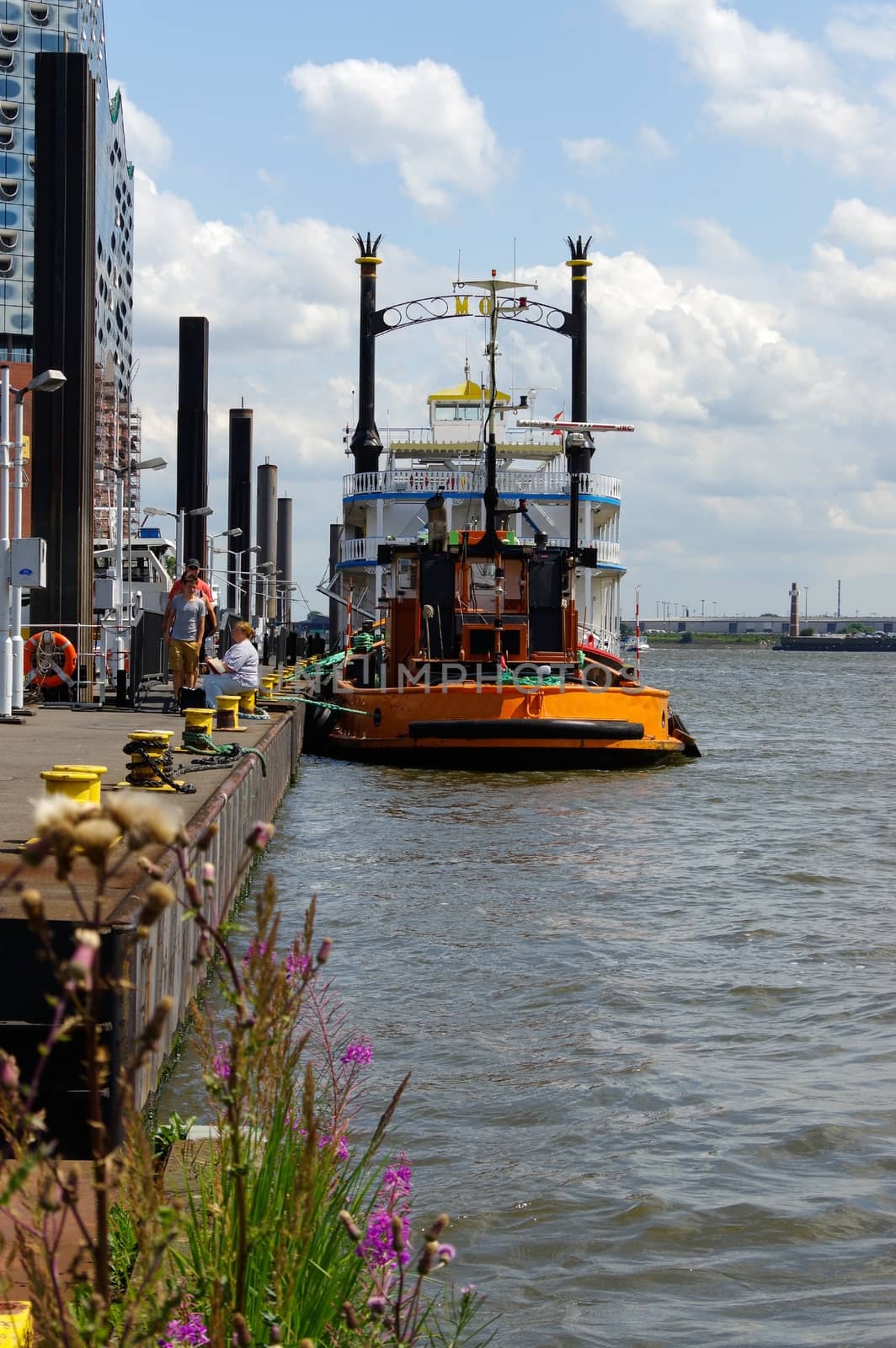 HAMBURG, GERMANY - JULY 18, 2015: yellow Tug Boat in the port of Hamburg at the pier by evolutionnow