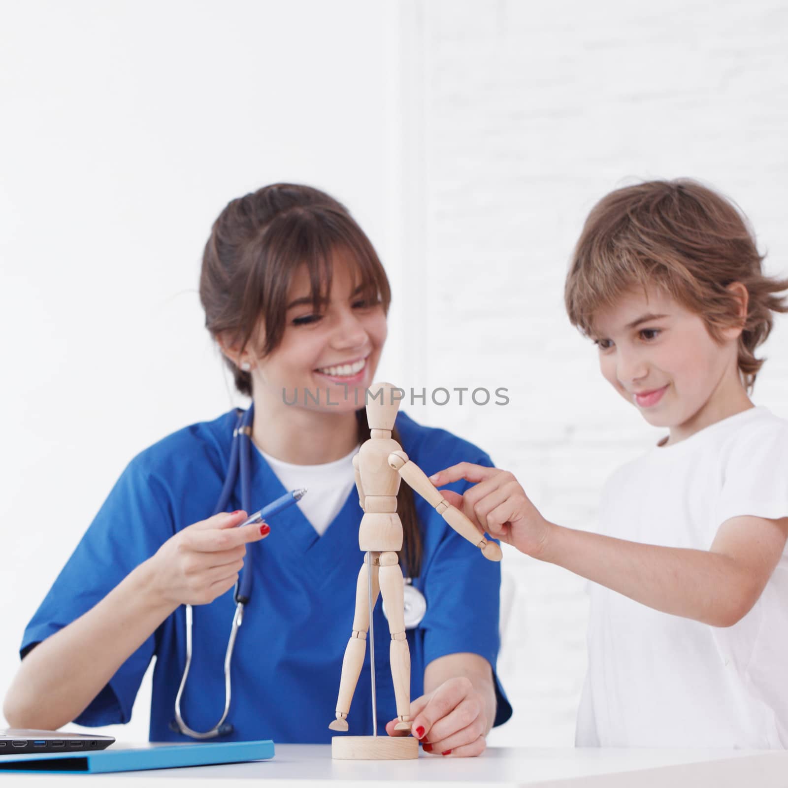 Doctor explain medicine to child using wooden doll