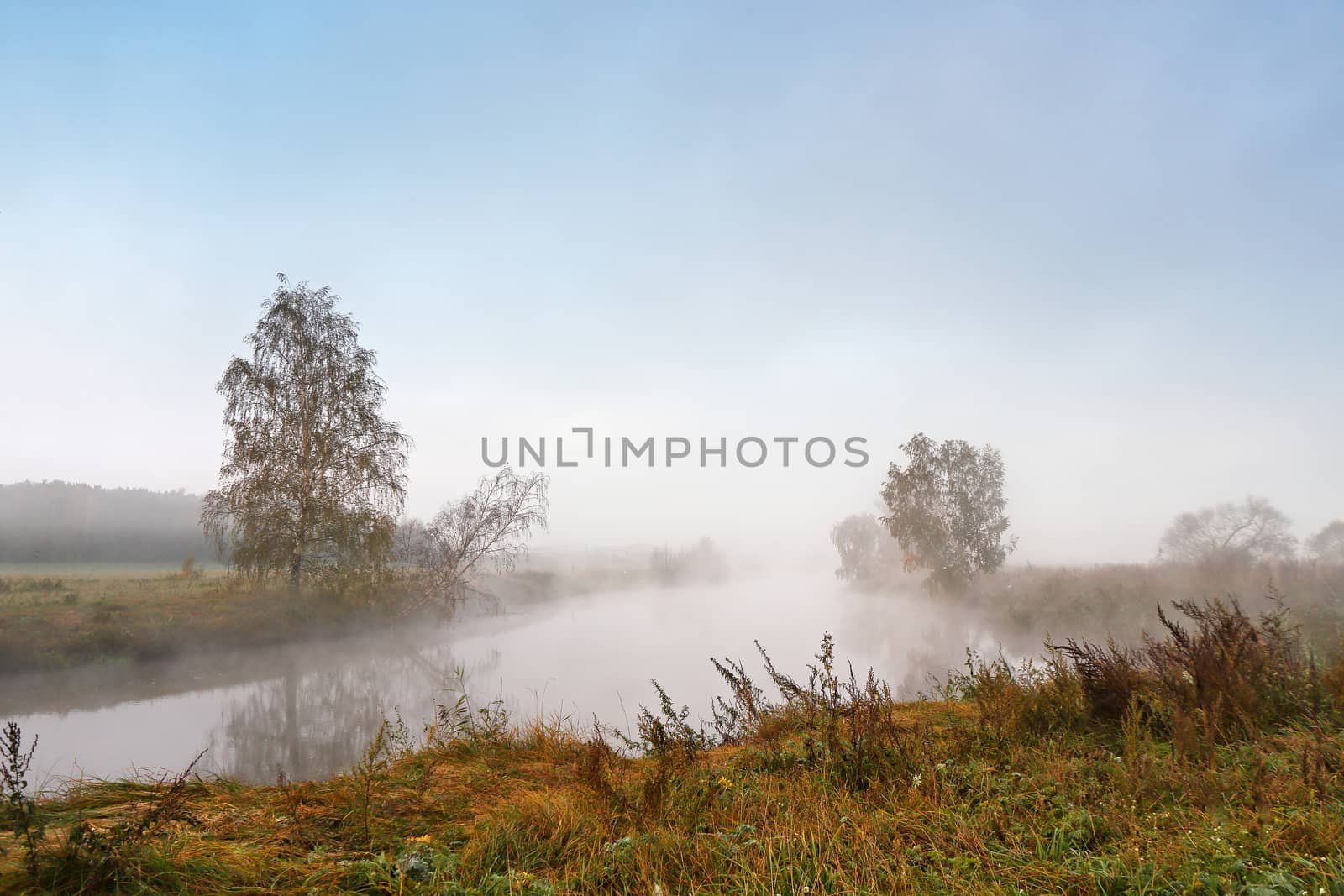 Autumn foggy morning. Dawn on the misty tranquil river