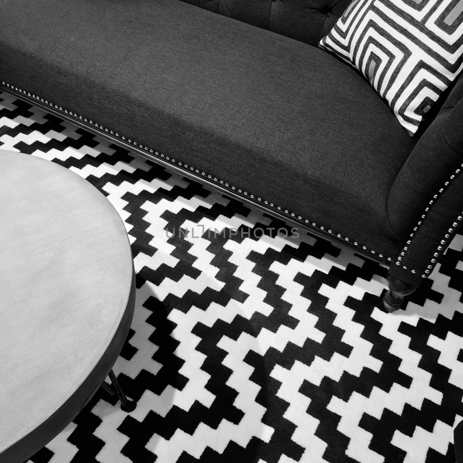 Stylish black and white interior with textile sofa and round table.