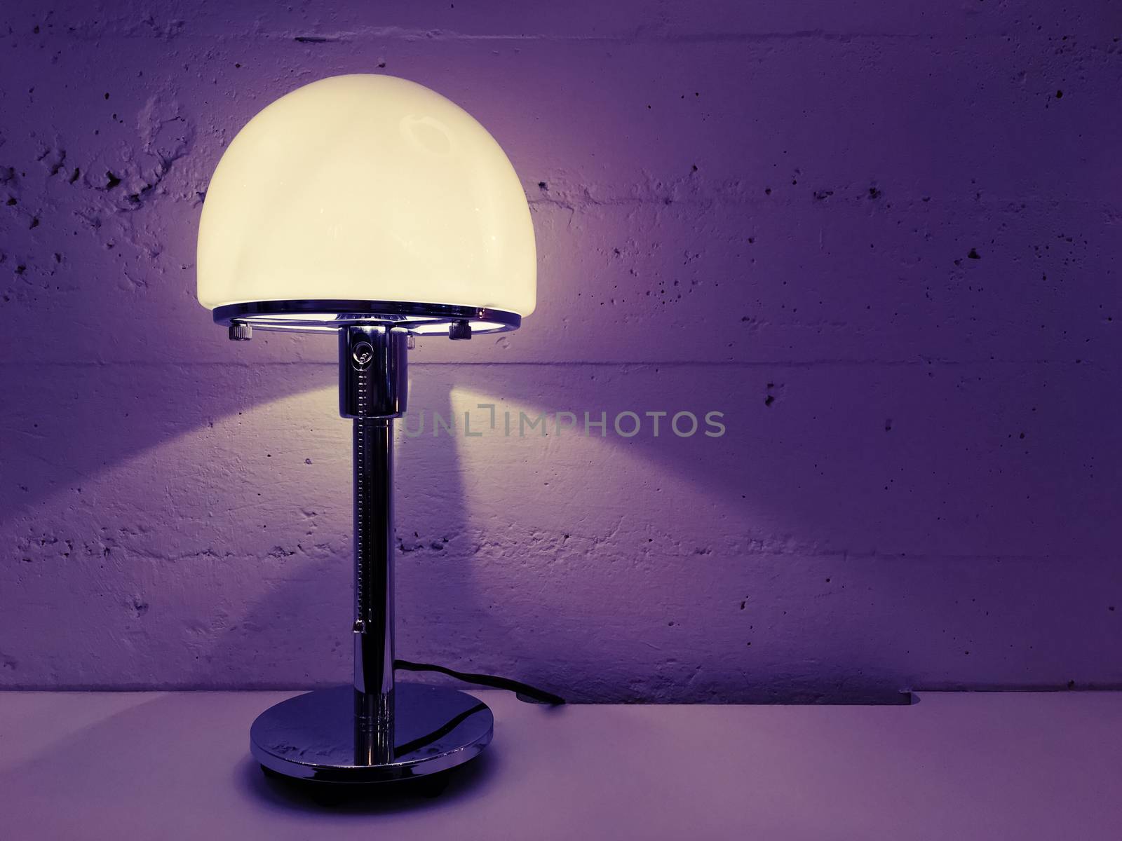 Modern design table lamp near concrete wall by anikasalsera