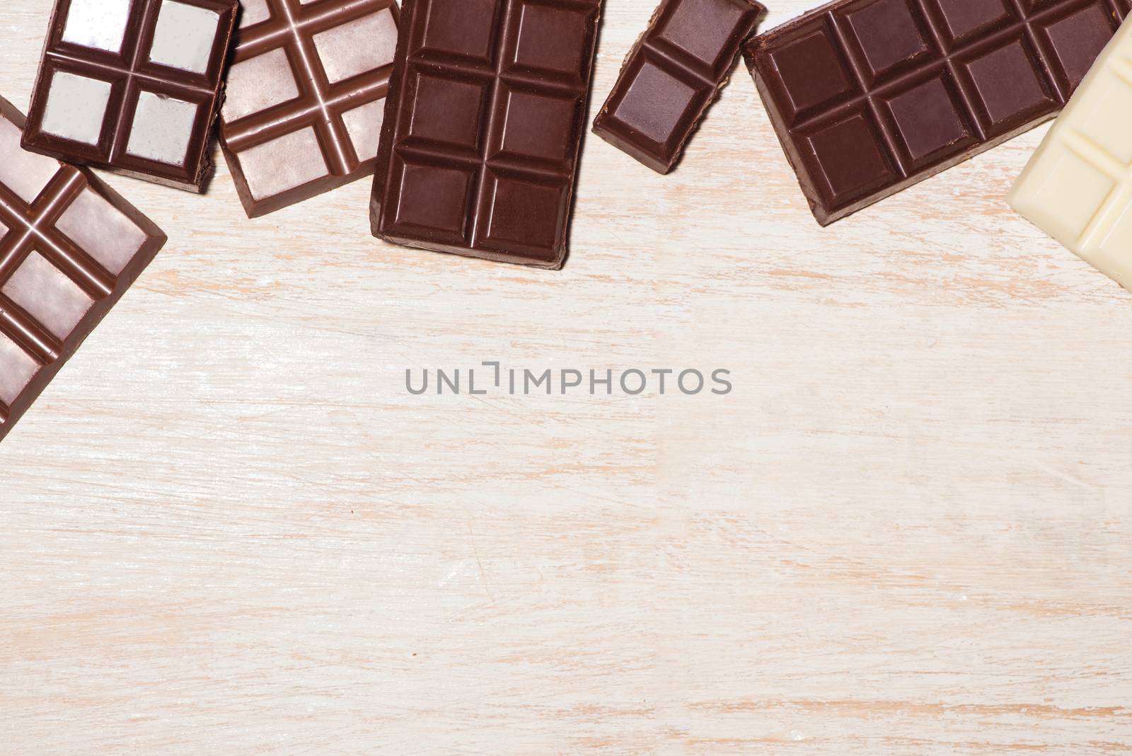 A lot of variety chocolates bar in box on white wooden background