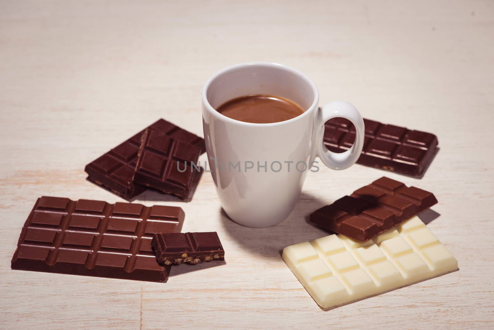 Glass of chocolate milk and variety chocolates  on table