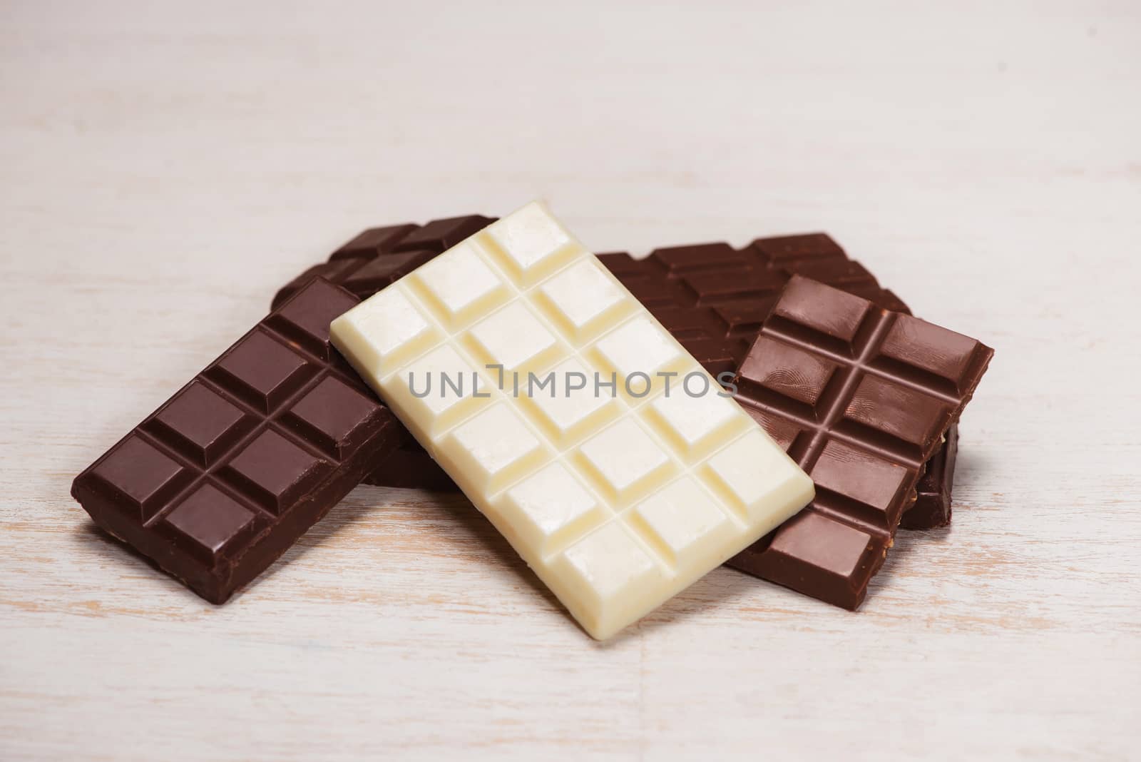 A lot of variety chocolates bar in box on white wooden background