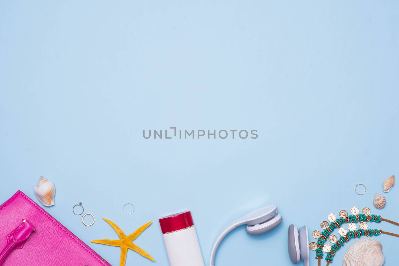 Summer concept. Pink handbag with accessories on light blue back by makidotvn