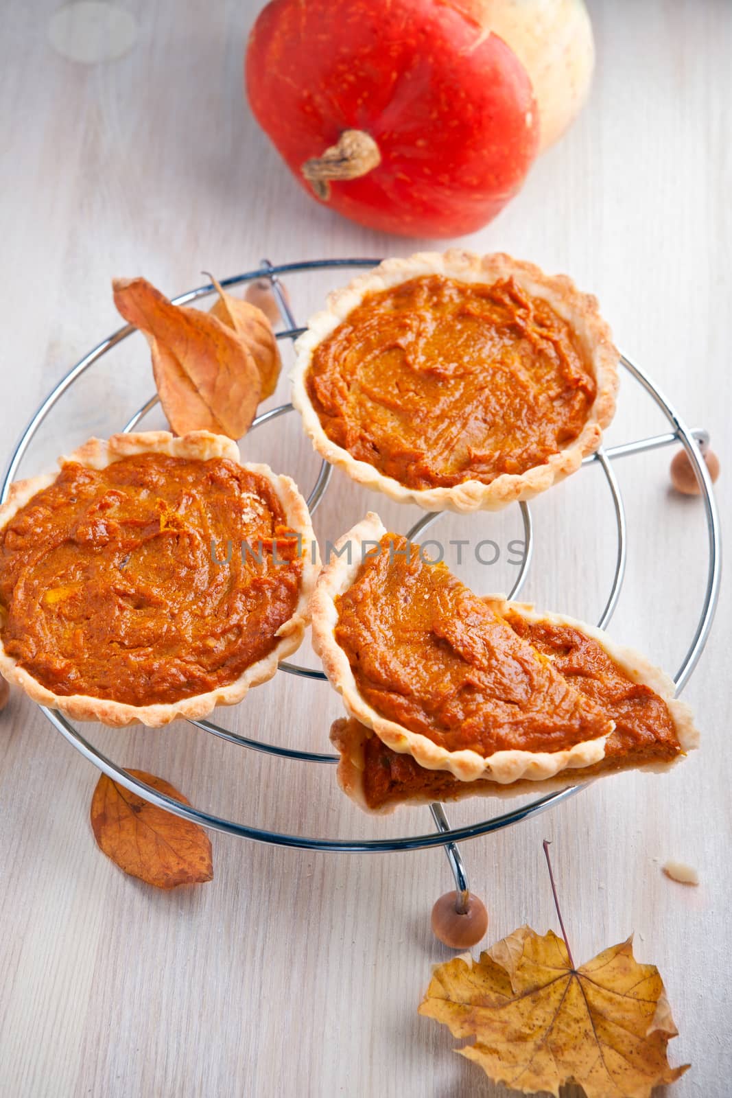 Pumpkin pie dessert with leaves on a table