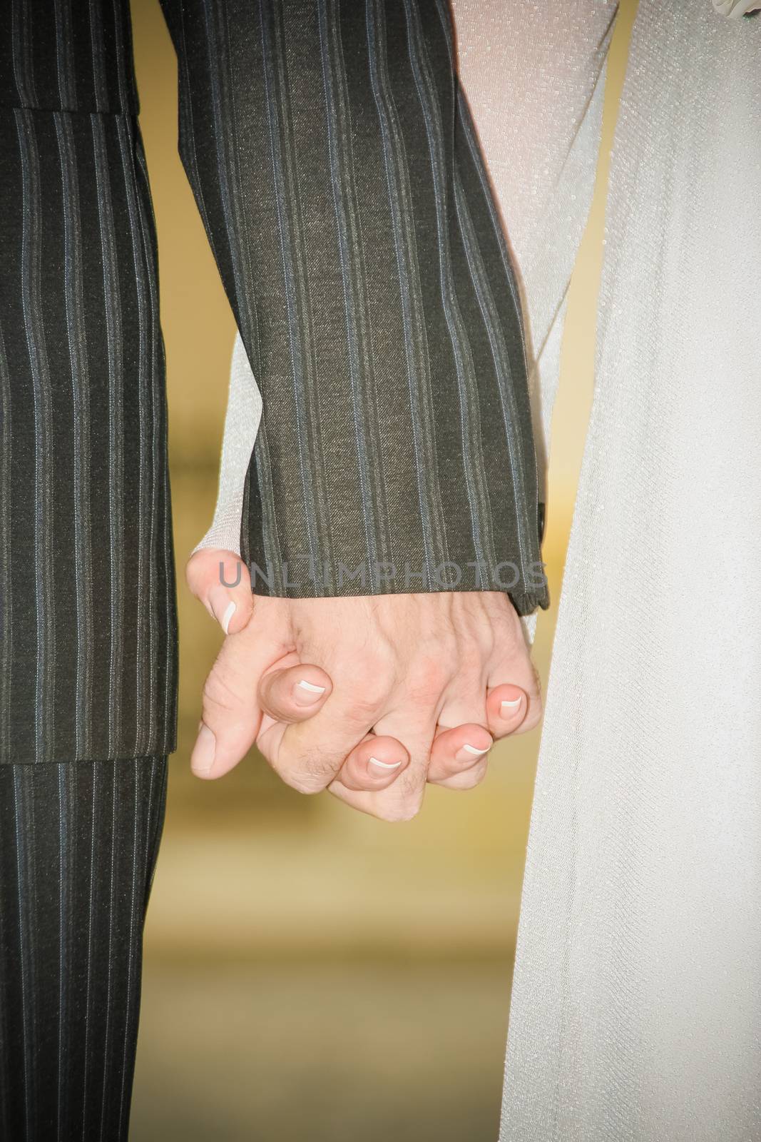 Young married couple holding hands ceremony wedding day