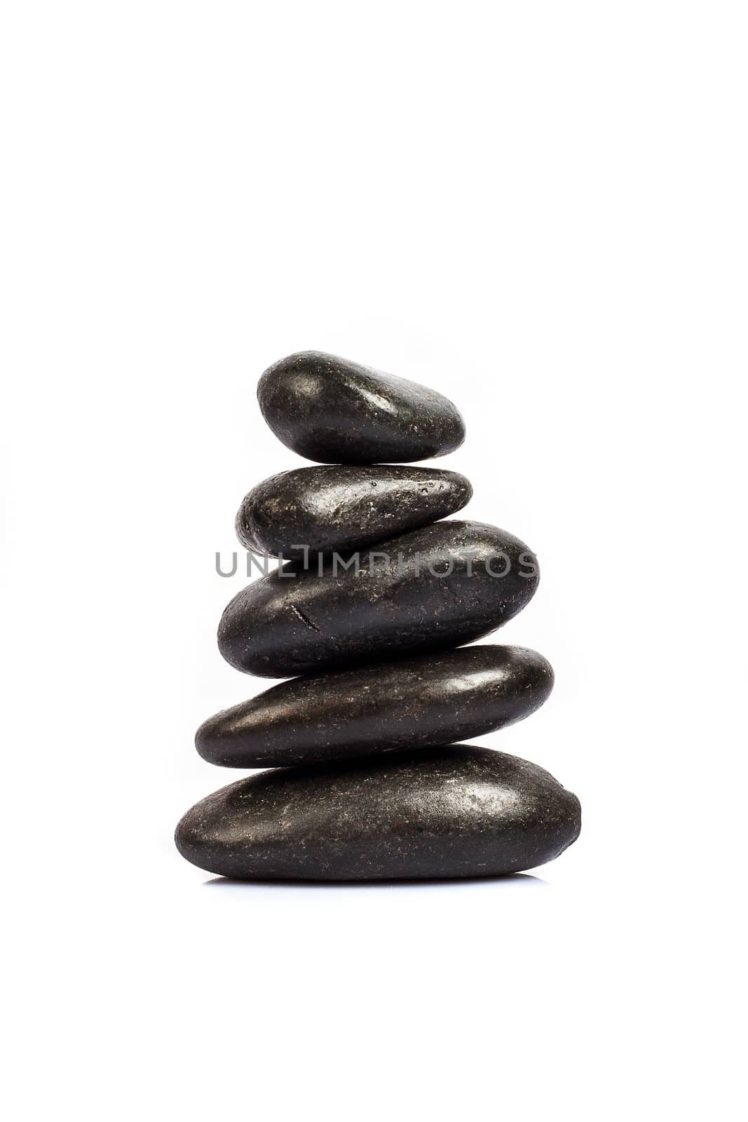 stack of five black stones on a white background