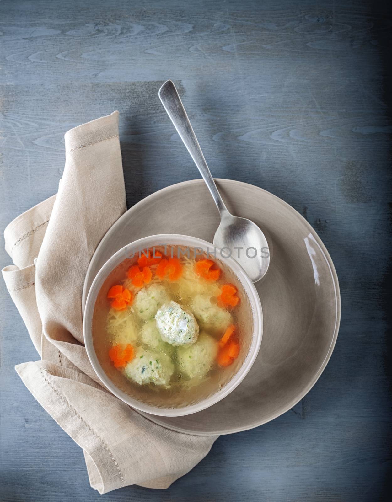 Chicken soup with meatballs and vegetables with a napkin