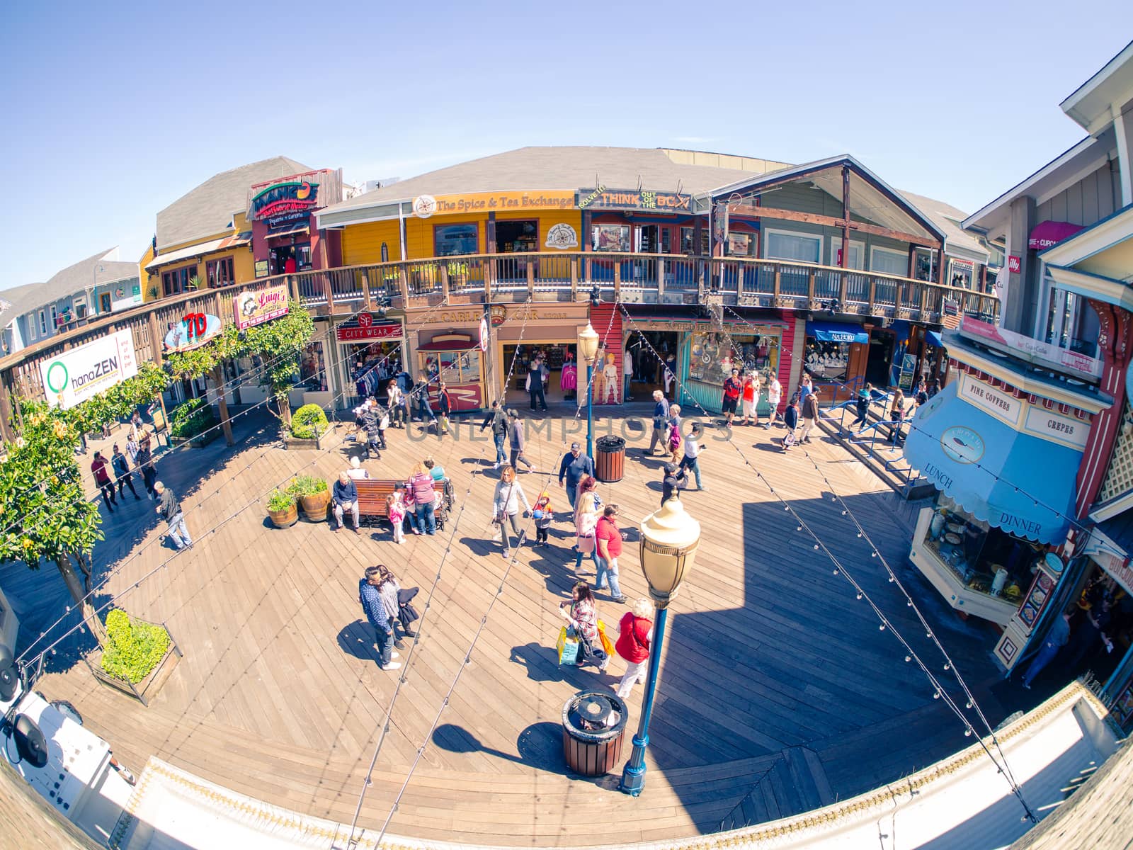 San Francisco, CA, USA - April 3, 2017: Groups of tourists, mainly families, walking at the Pier 39, Fisherman's Wharf