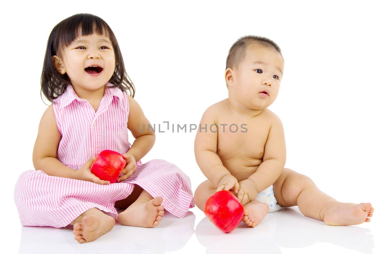 Portrait of lovely asian kids holding an apple playing on the floor