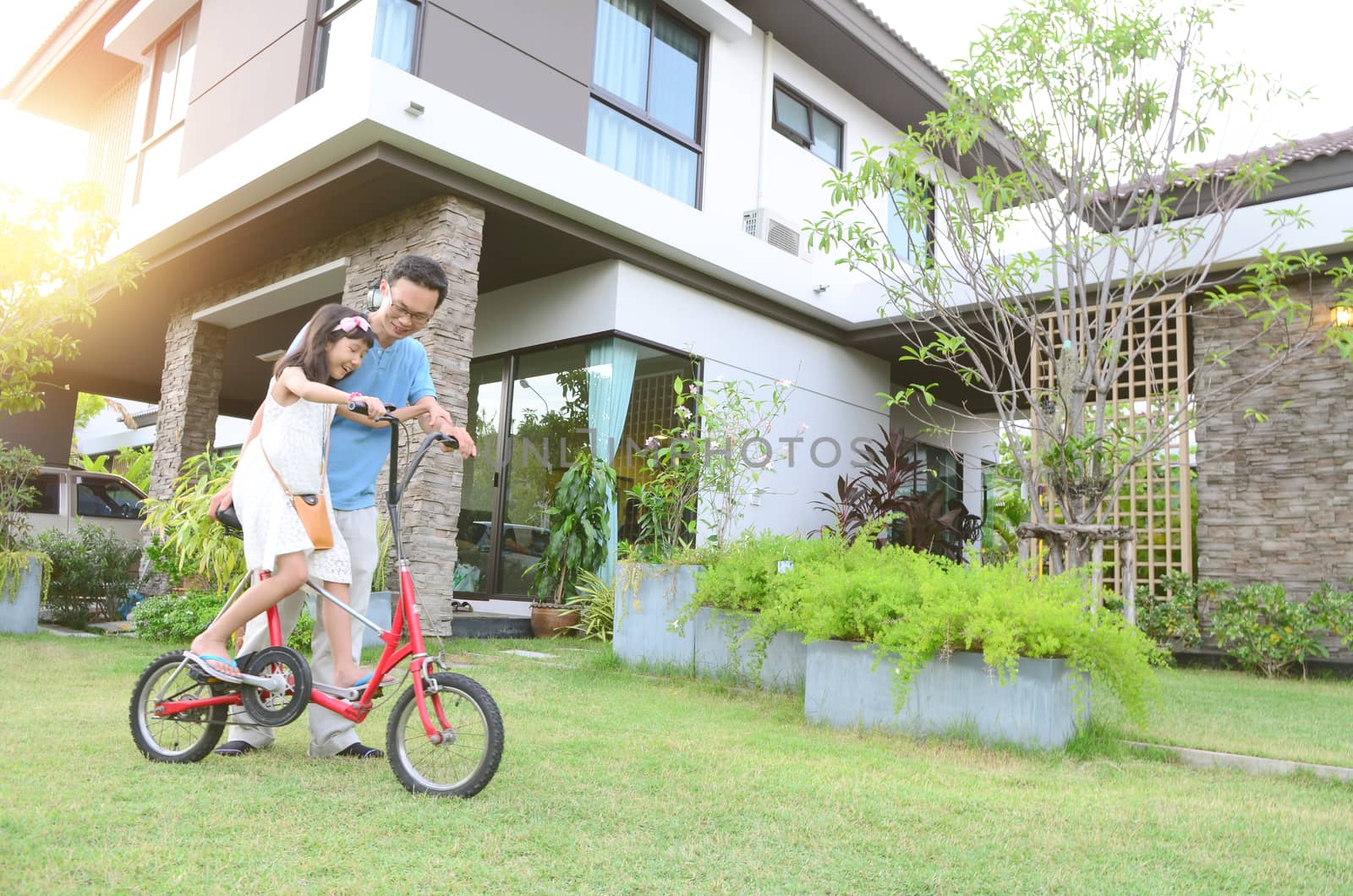 Healthy father and daughter playing together outside their new house. Home fun  lifestyle, family concept.