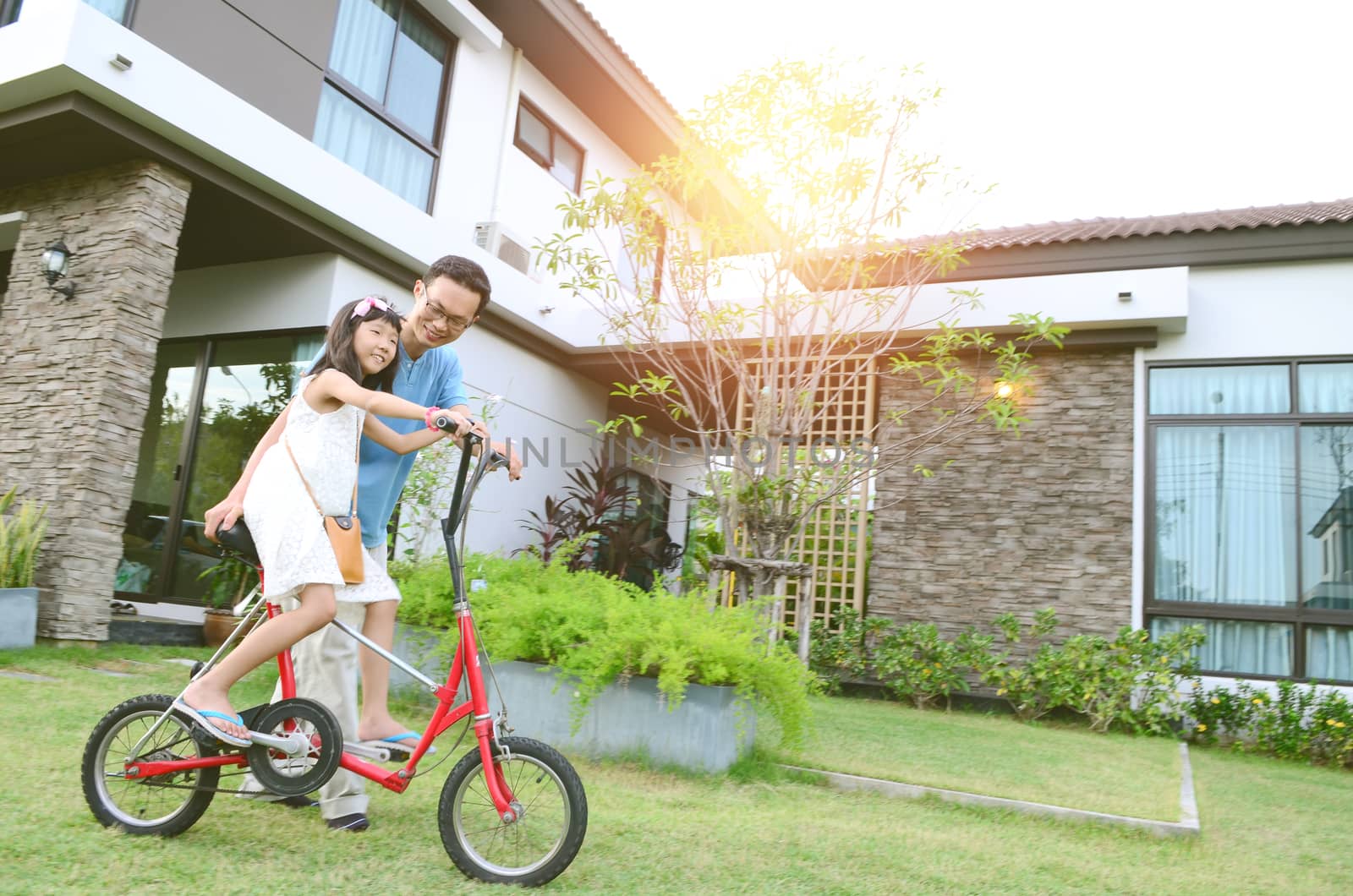 Healthy father and daughter playing together outside their new house. Home fun  lifestyle, family concept.