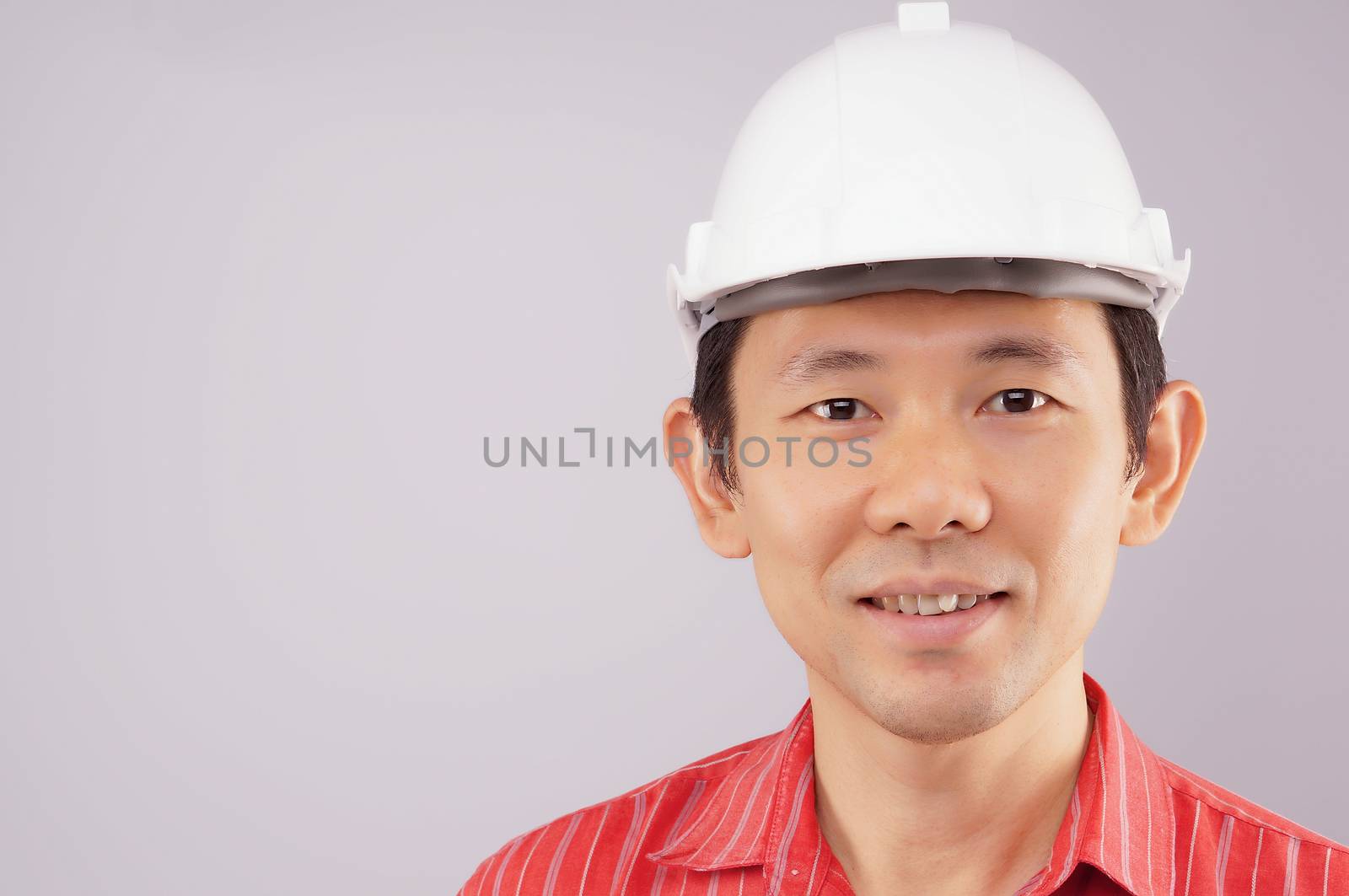 Happy engineer wear red shirt and white engineer hat look to the front on white background.