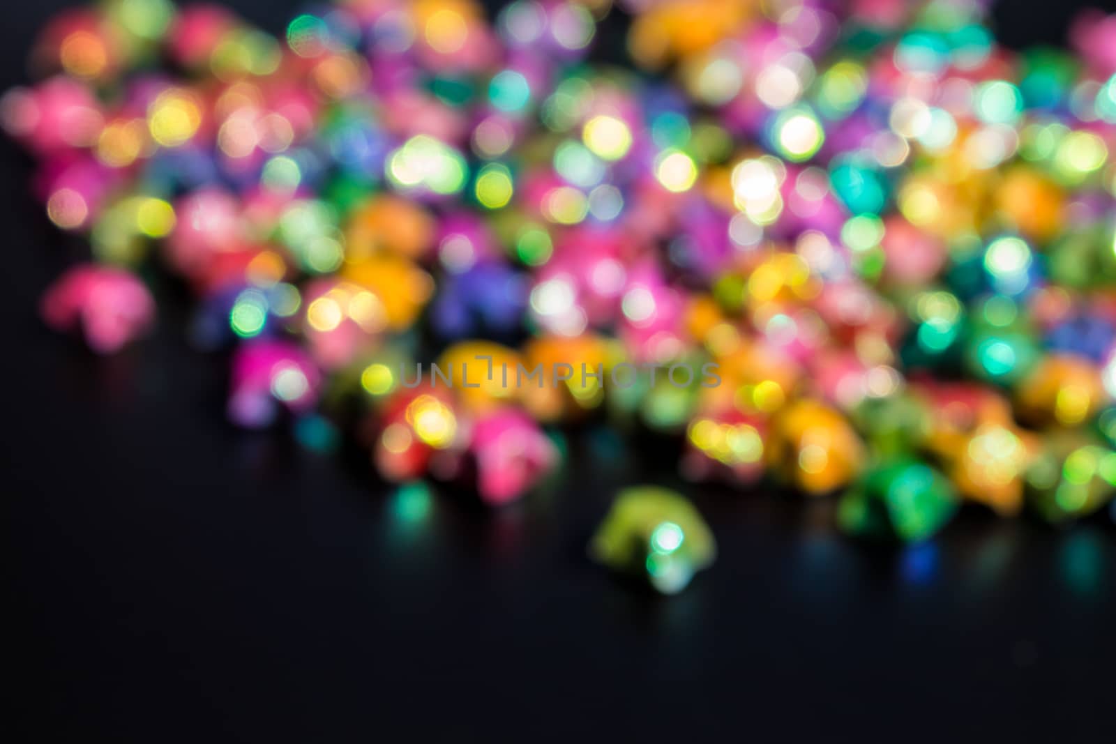 blured bokeh from colorful star paper on black background