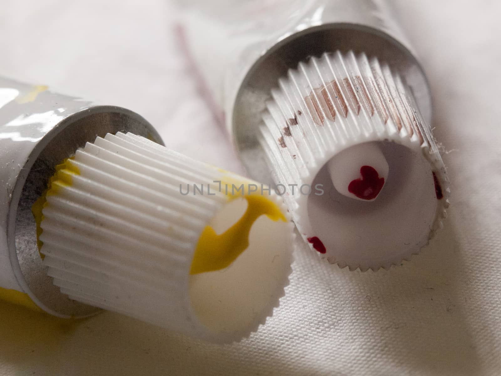 two tubes of used paints on white background studio