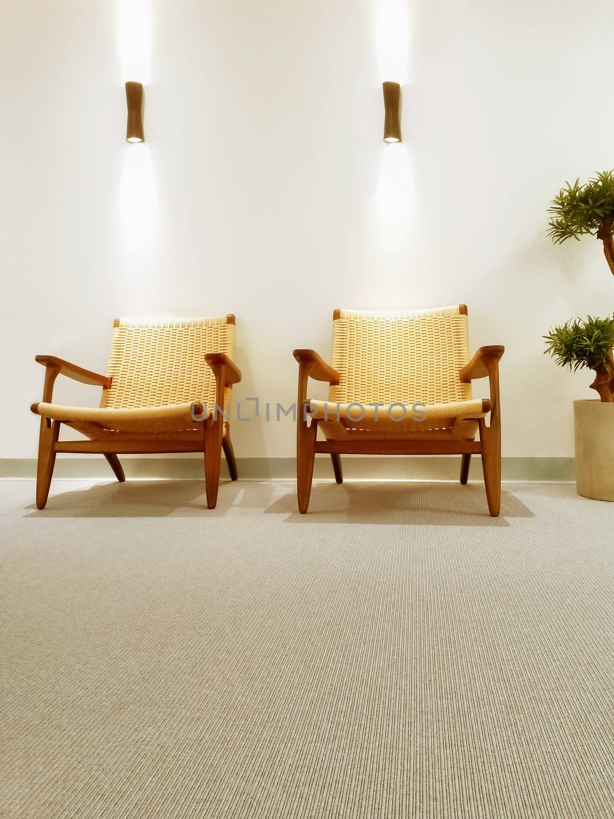 Interior with classic rattan chairs and carpet floor.