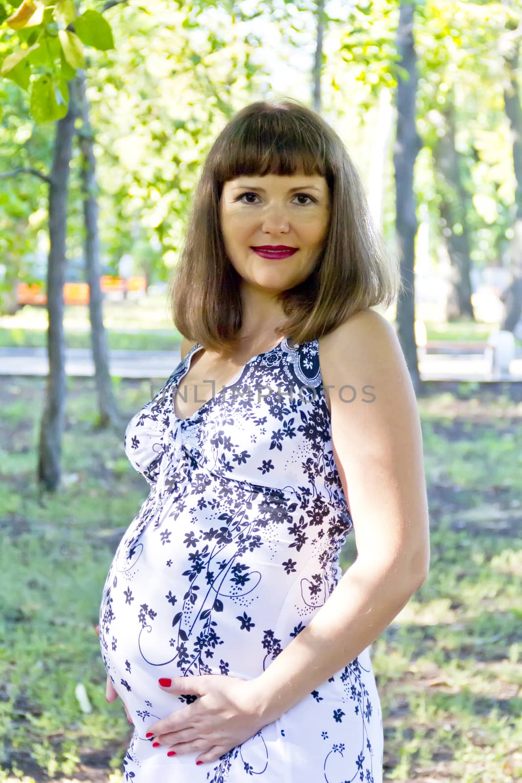 Pregnant woman with brown hair in summer