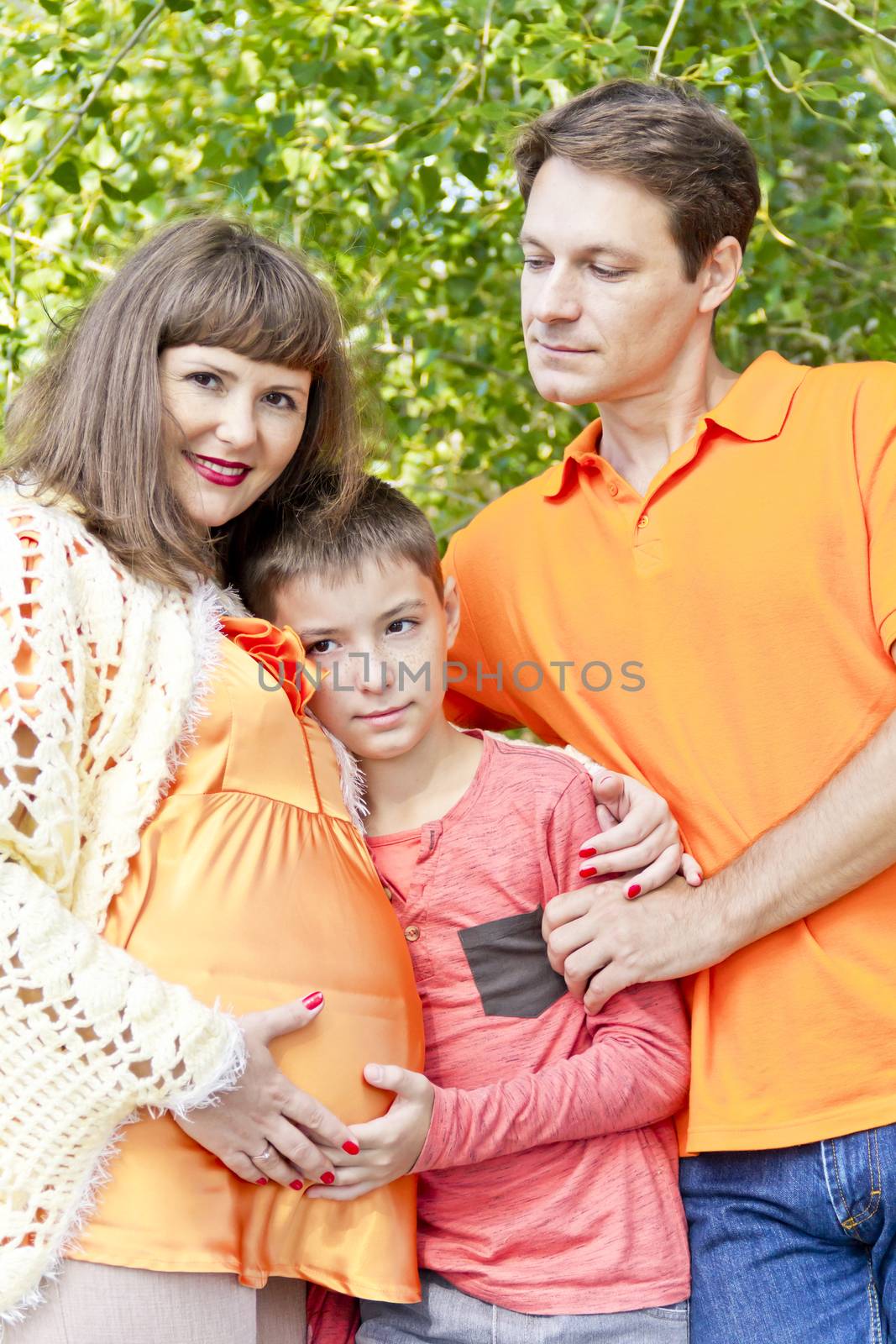 Portrait of happy family mother father and son awaiting baby