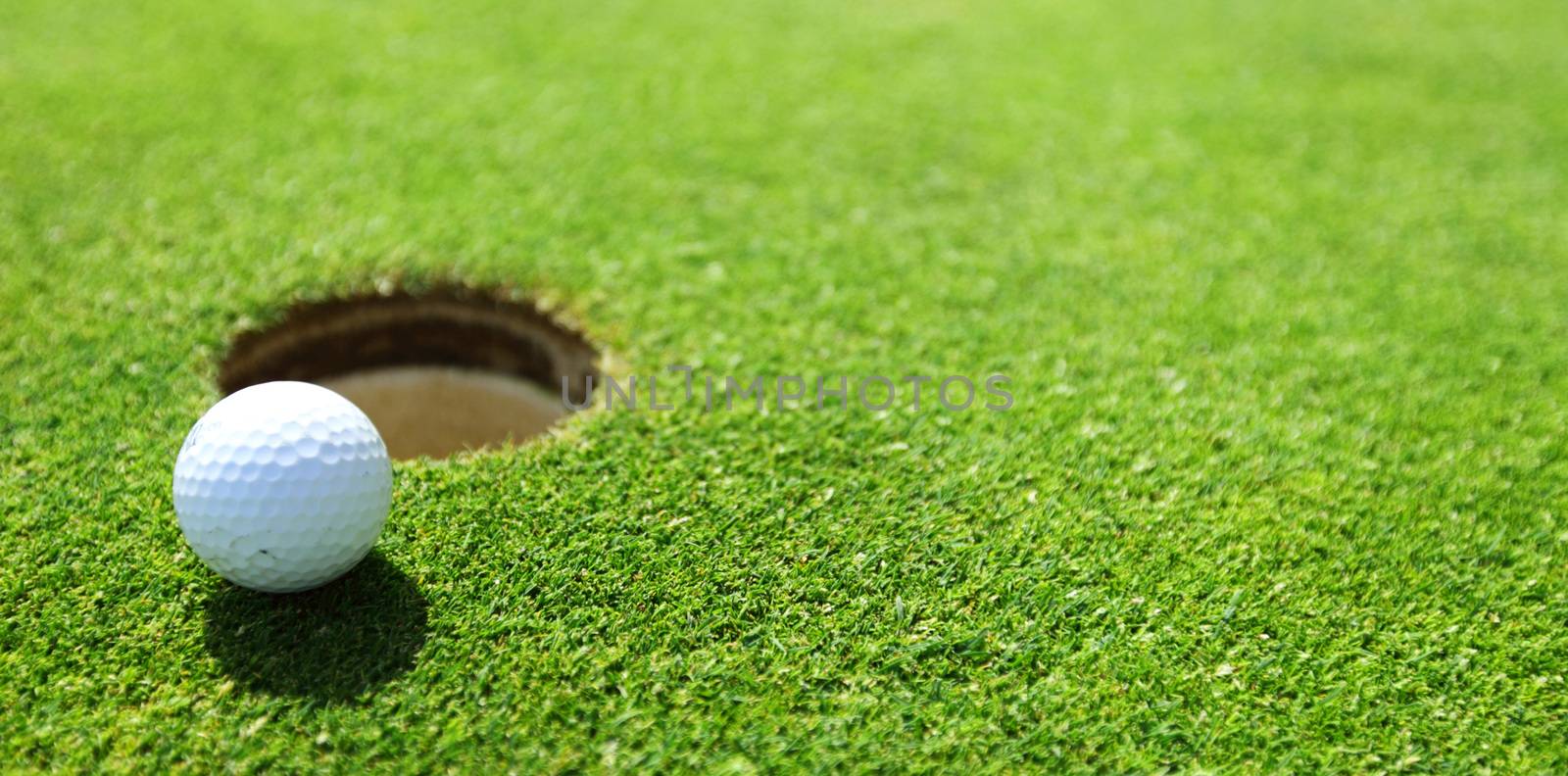 golf ball on lip of cup close up