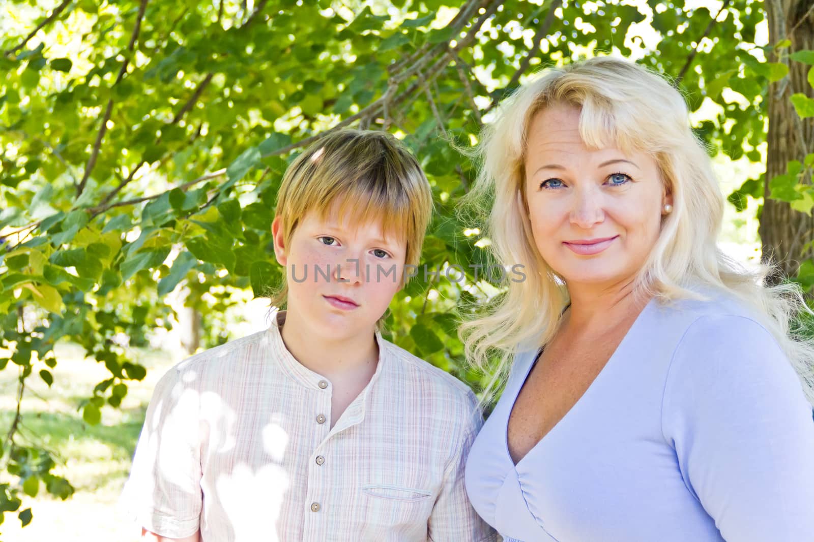 Blond woman and son smiling in summer by Julialine