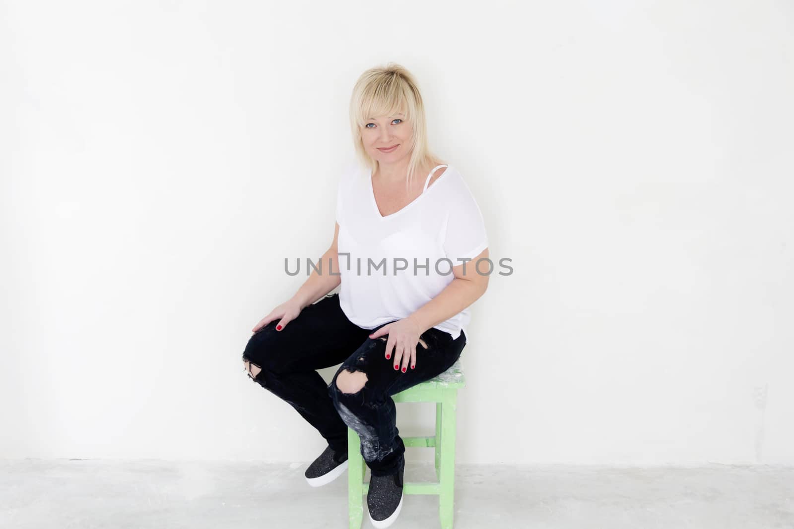 Blond woman in white and black jeans inside empty room