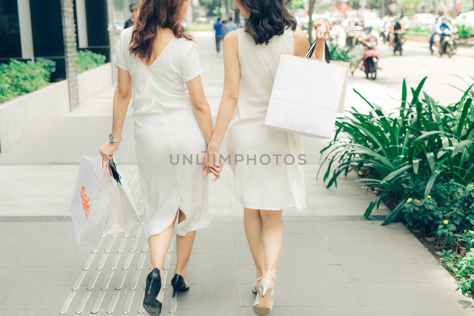 Beautiful asian girls with shopping bags walking on street at th by makidotvn